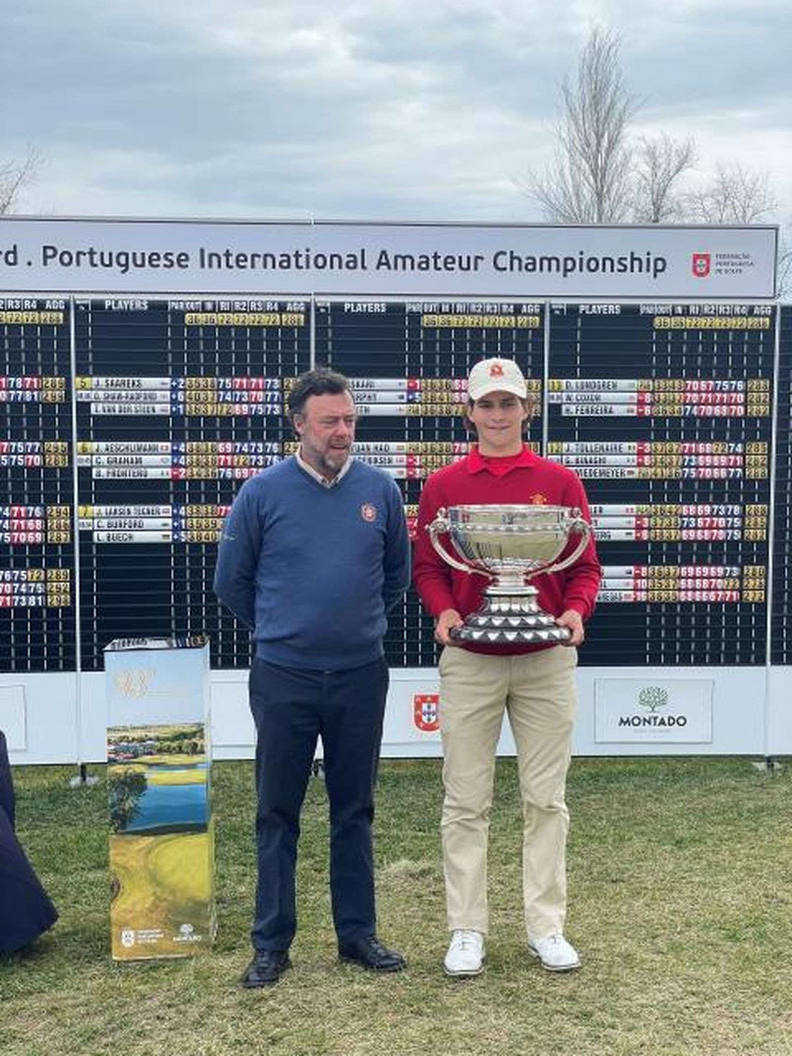 Ángel Ayora, con su trofeo, ante la tabla de clasificaciones