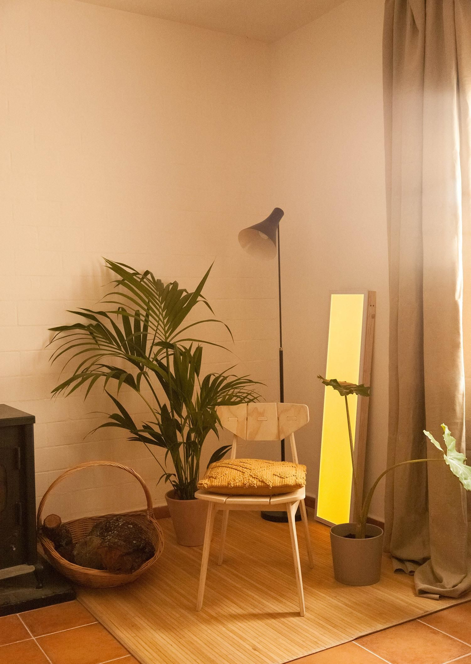 Un panel LED recrea una ventana en la decoración en colores amarillos de un salón.