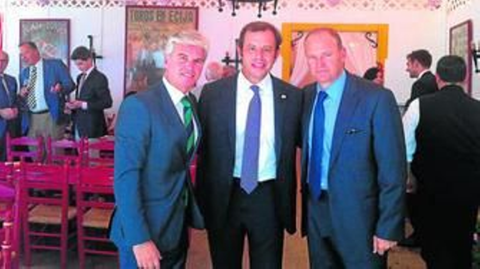 El presidente del Betis, Miguel Guillén, y el entrenador, Pepe Mel, posan junto al presidente del Barcelona, Sandro Rosell, en la Feria.