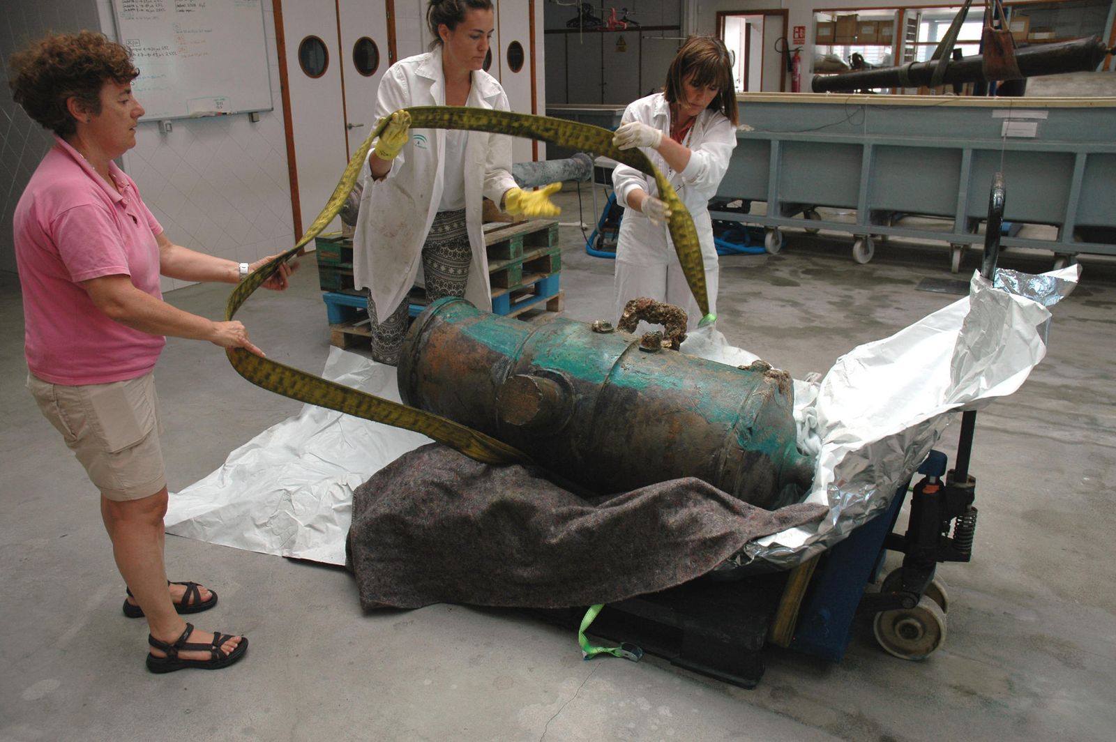 Los técnicos trasladan la pieza procedente de las aguas de la dársena de Cádiz al CAS.