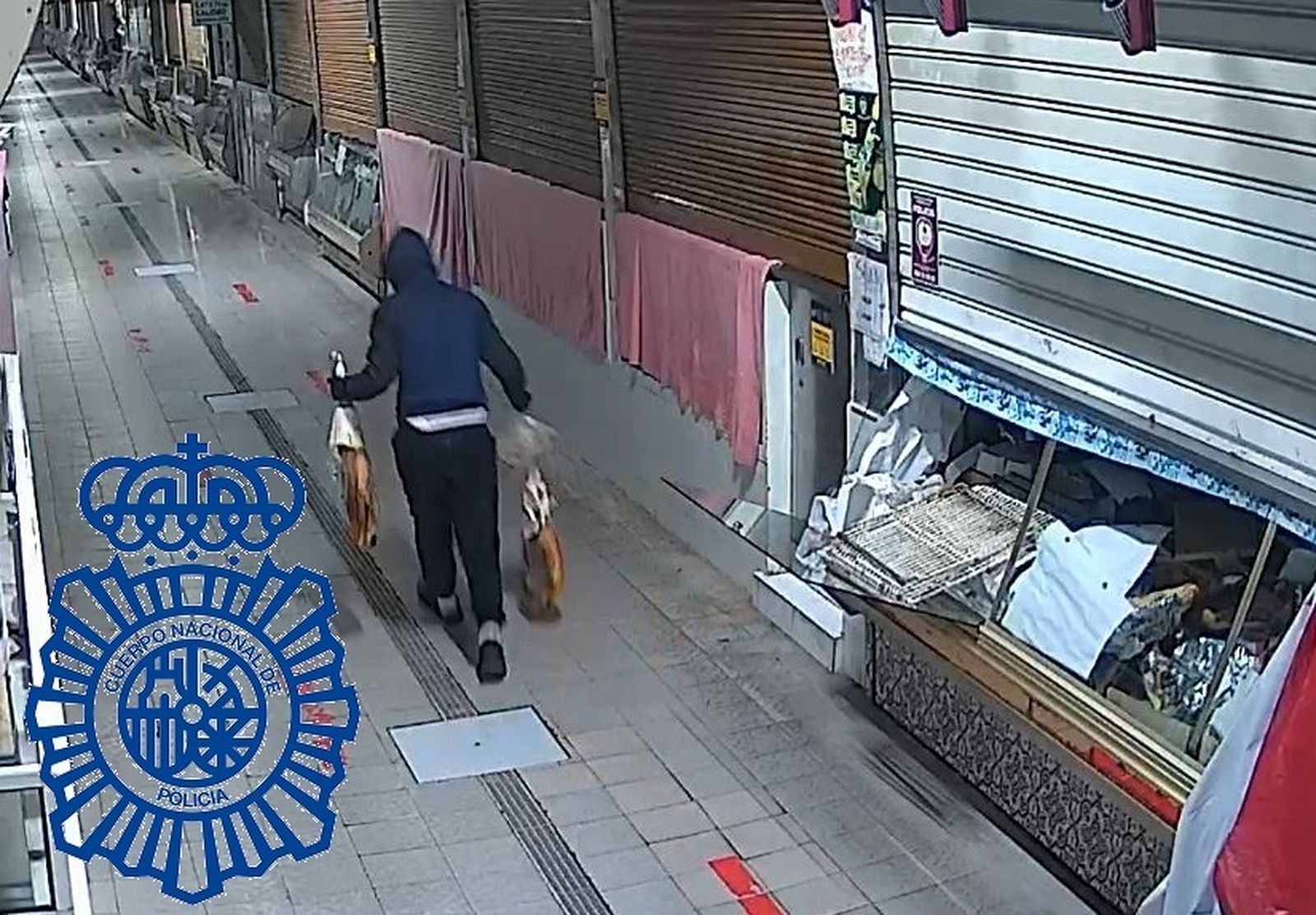 El hombre con los dos jamones aún en el interior del mercado.