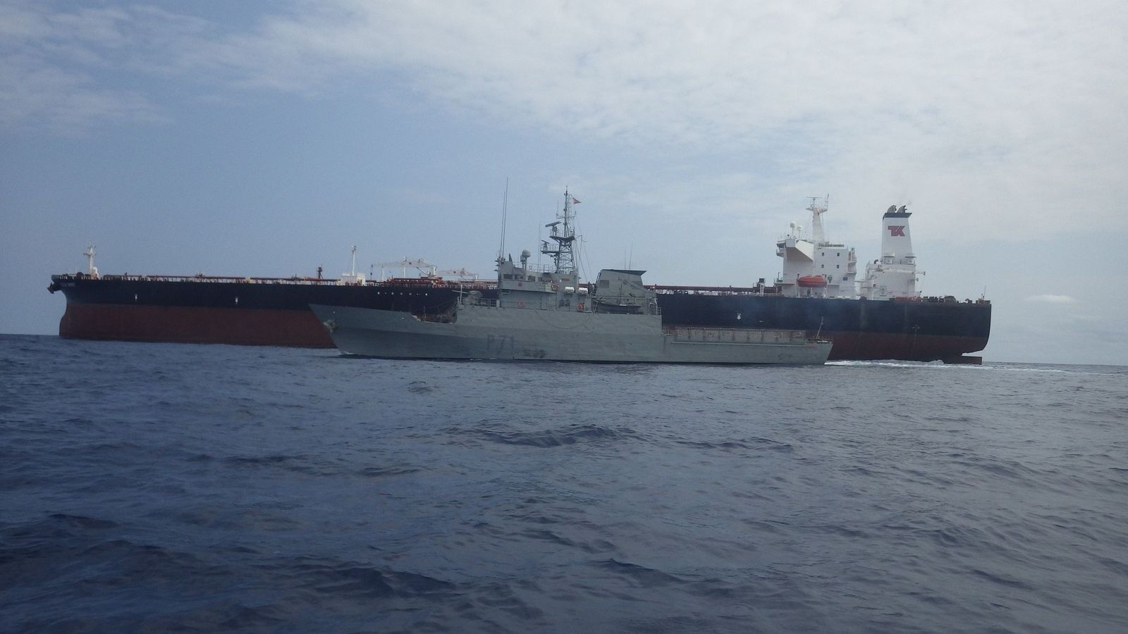 El patrullero 'Serviola', junto a un buque mercante.