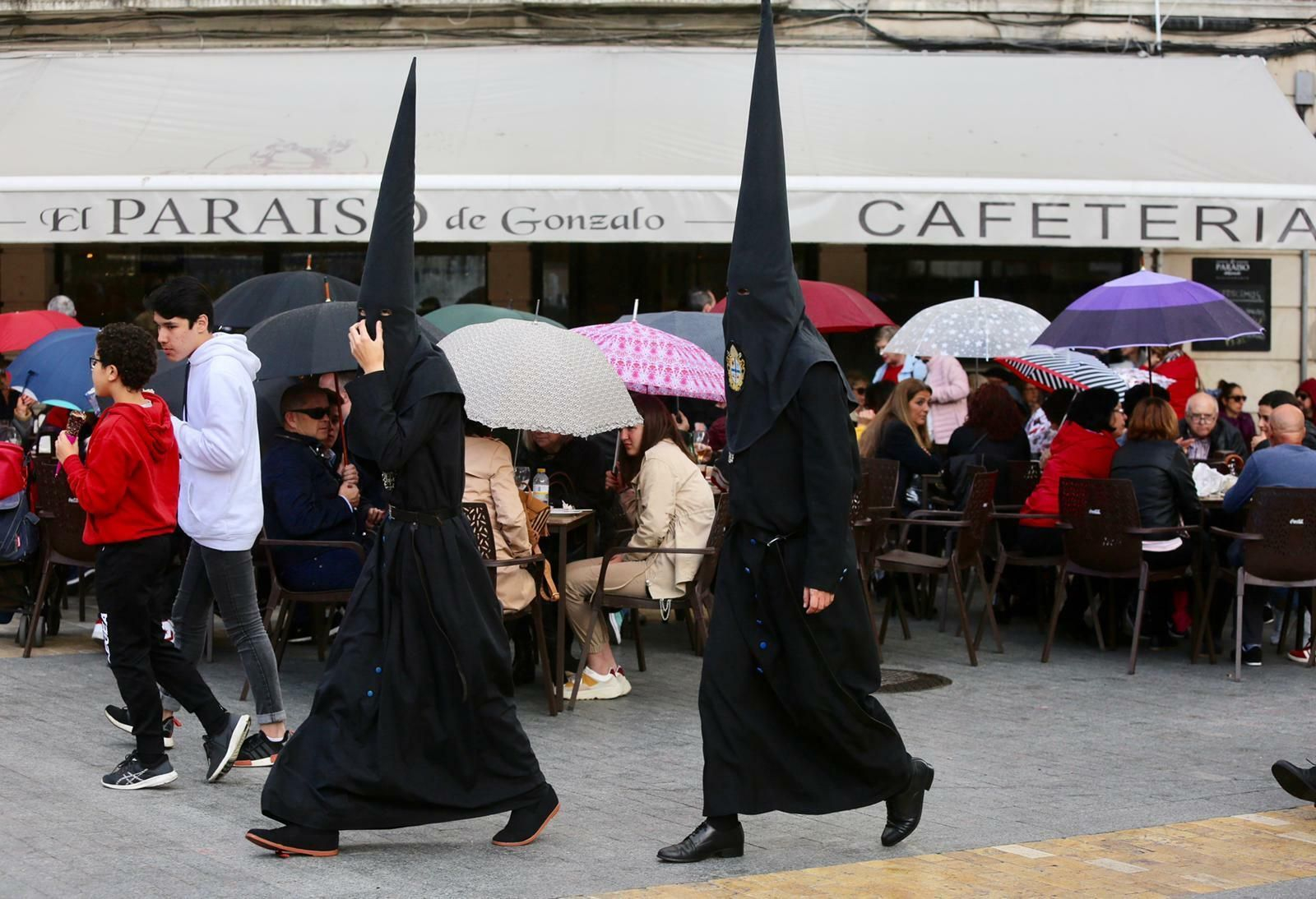 Paraguas y nazarenos se mezclan en el tramo final de la Semana Santa onubense. Paraguas y nazarenos se mezclan en el tramo final de la Semana Santa onubense.