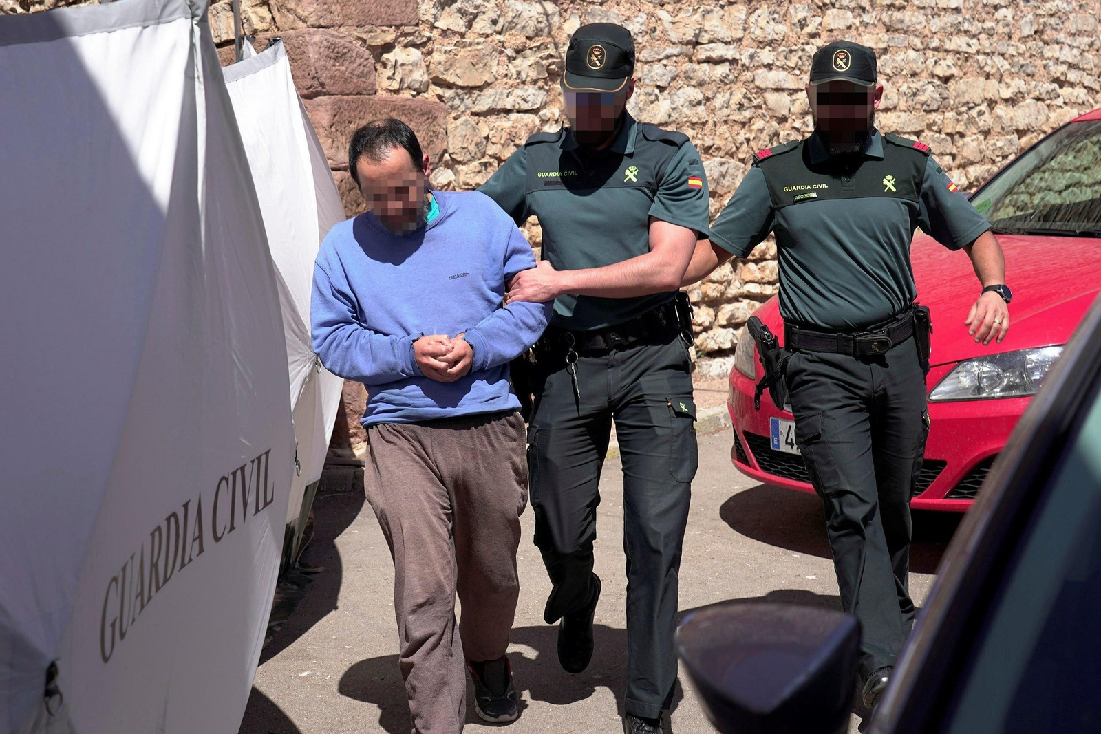 El hijo de la mujer hallada muerta en el domicilio familiar en la localidad de Pozondón, acompañado por agentes de la Guardia Civil, durante la reconstrucción de los hechos.
