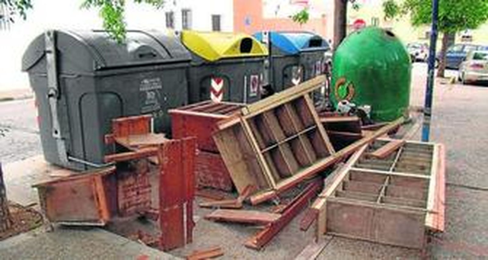 Restos de muebles, depositados junto a contenedores de residuos cerca del cementerio.