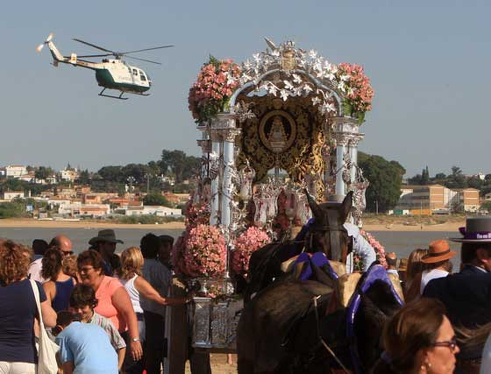Un helicóptero de la Guardia Civil sobrevuela la desembocadura del Guadalquivir con el Simpecado ya en Doñana.  

Foto: Juan Carlos Toro
