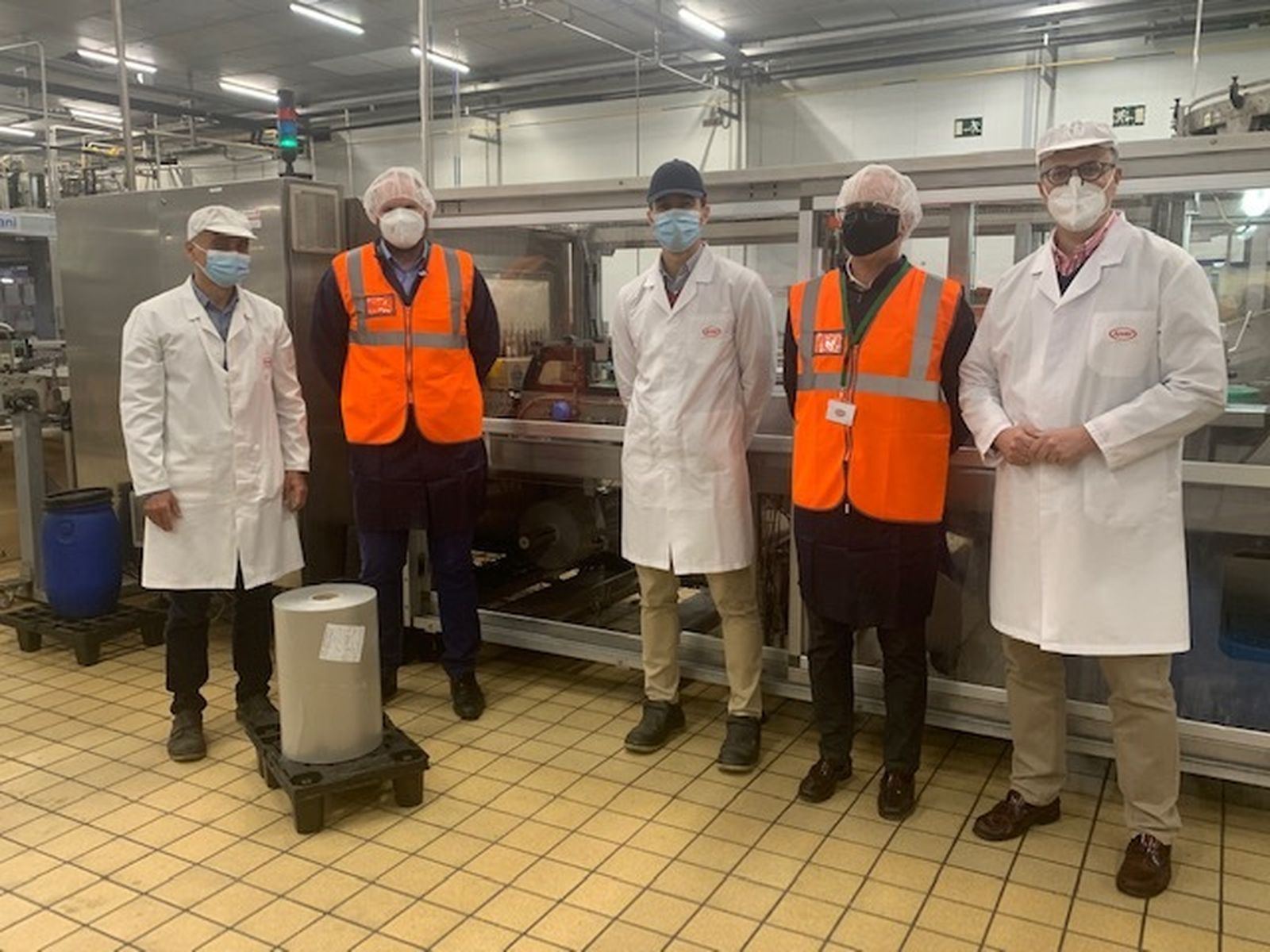 Planta de Juver Alimentación con los responsables y técnicos alrededor de la bobina de "film".