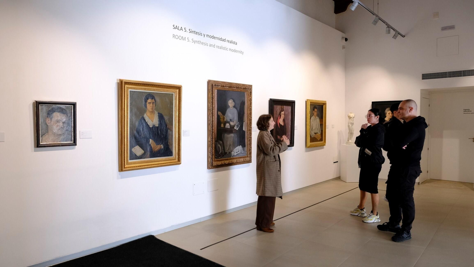 Un pequeño grupo atiende a las explicaciones de una de las guías del Museo del Realismo Español Contemporáneo.