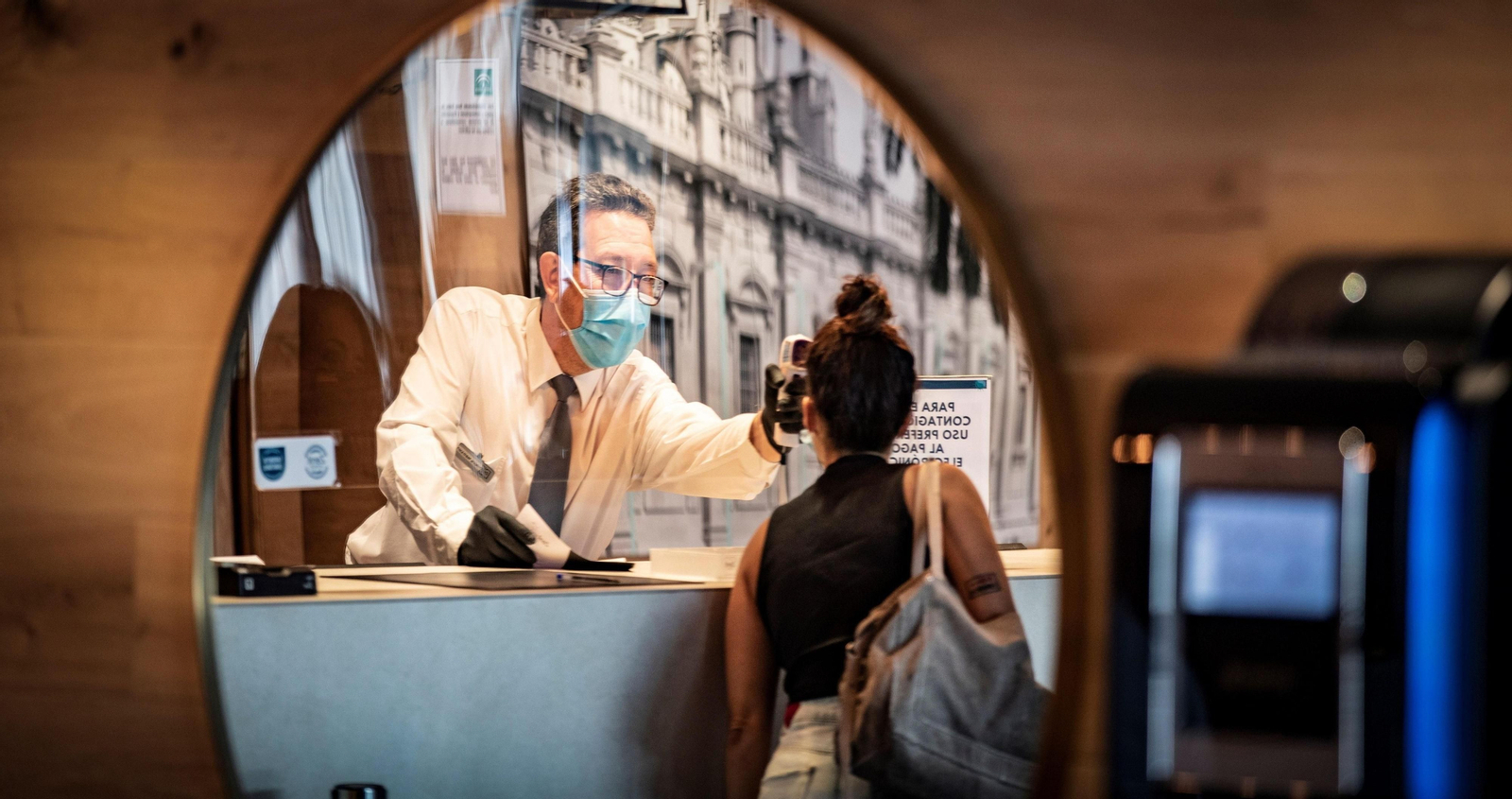 Un recepcionista atienda a la cliente de un hotel.