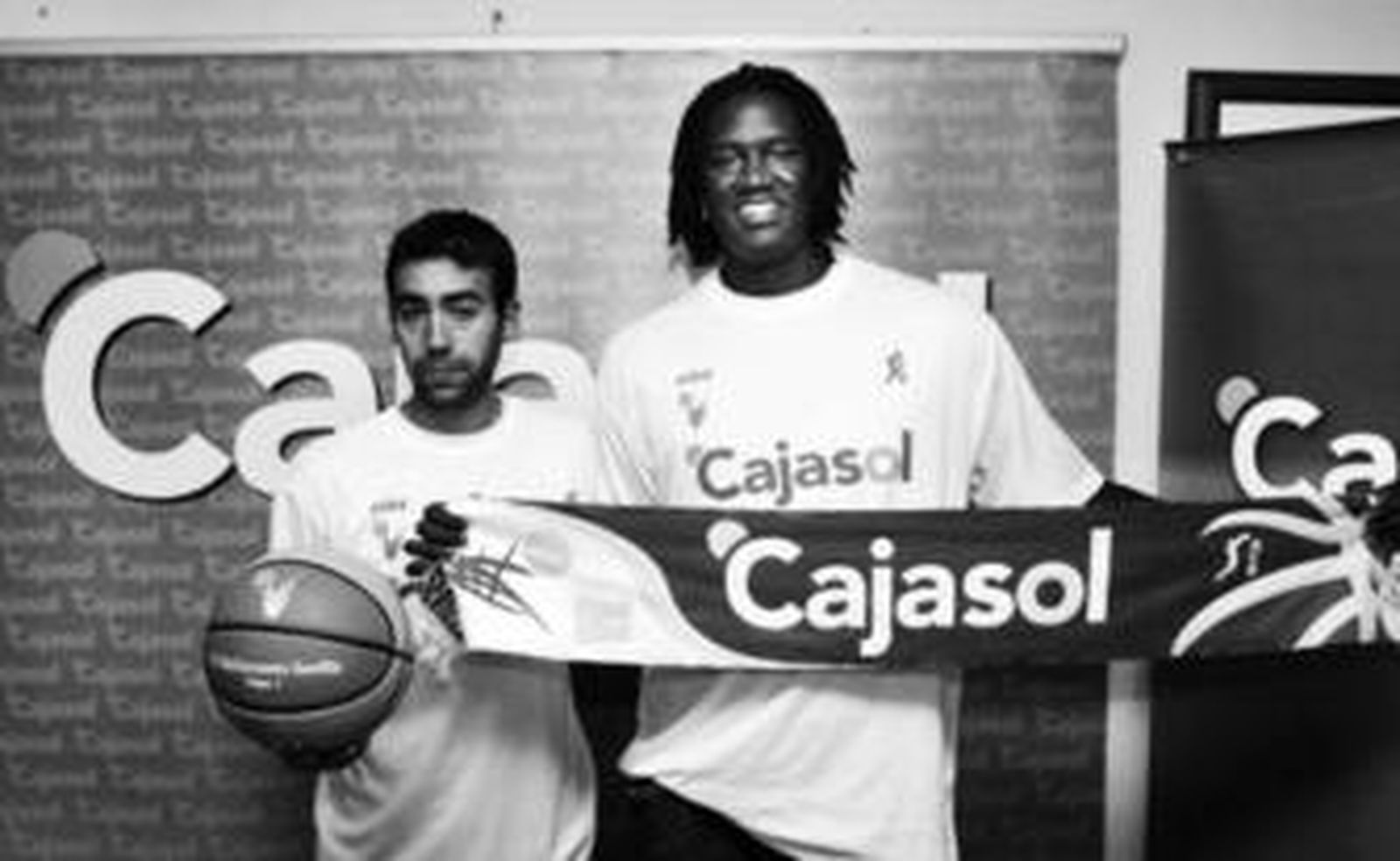 Pedro Rivero y Warren Carter posan con una camiseta, un balón y una bufanda del Cajasol.