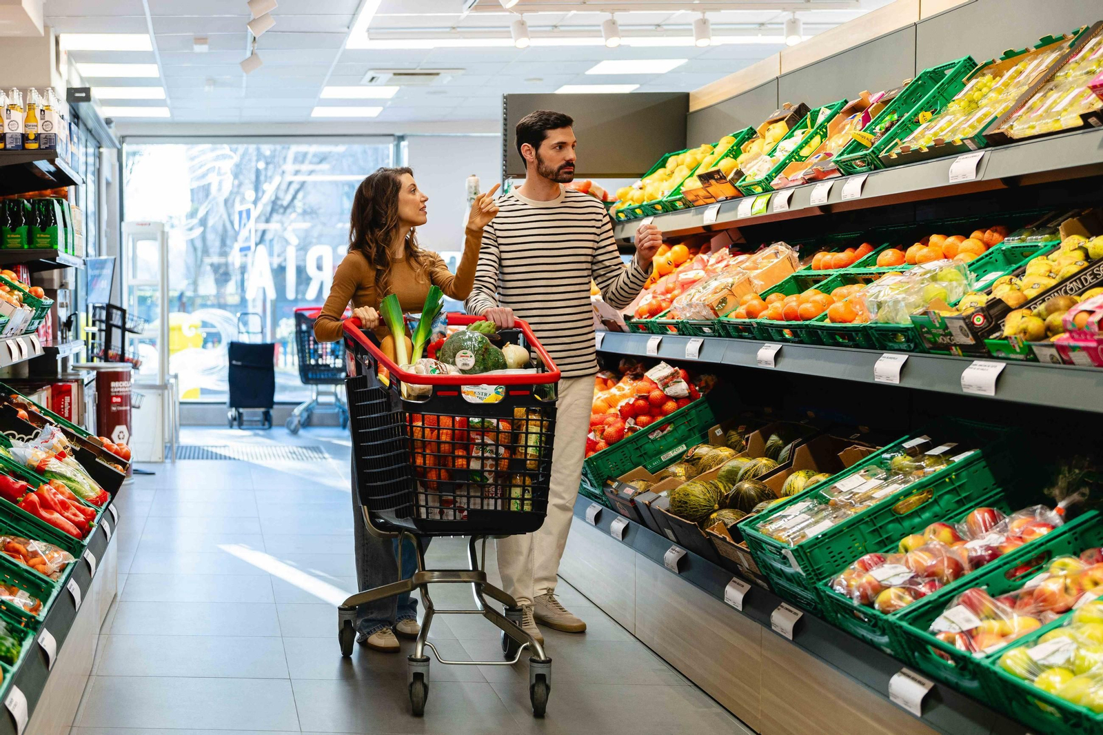 Dos personas transitan por la zona de productos frescos de una tienda Dia.
