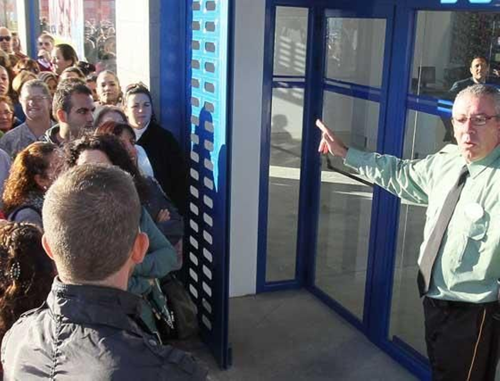 El vigilante de seguridad de GMI, ayer, con serios problemas para frenar la avalancha de público a la tienda de Luz Shopping.

Foto: miguel ángel gonzález