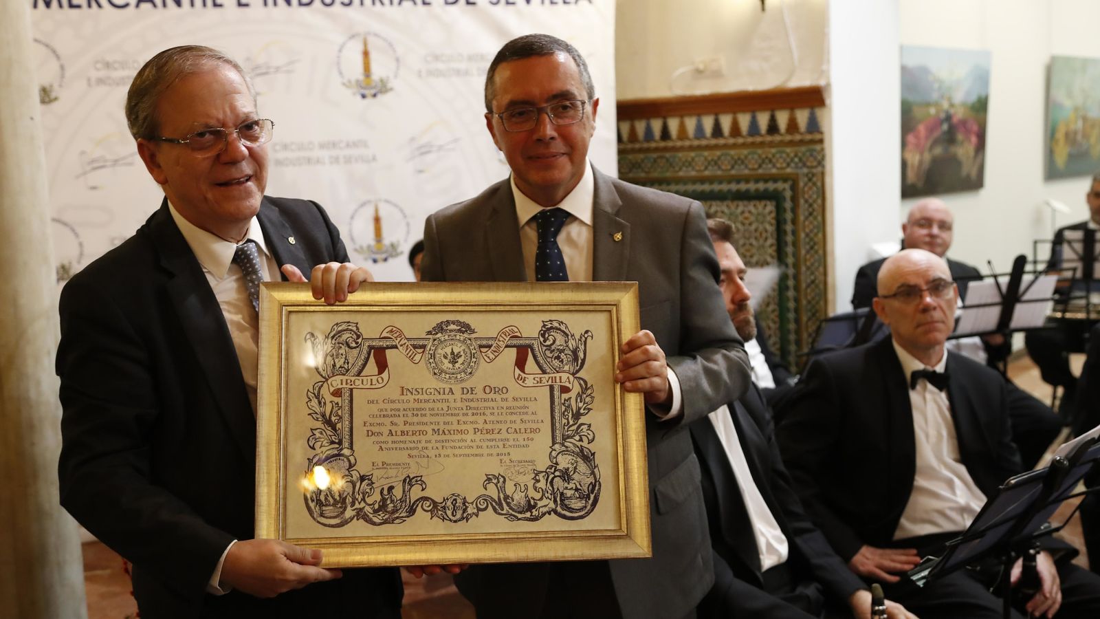 Alberto Máximo Calero recibe la insignia de oro de manos de Práxedes Sánchez.