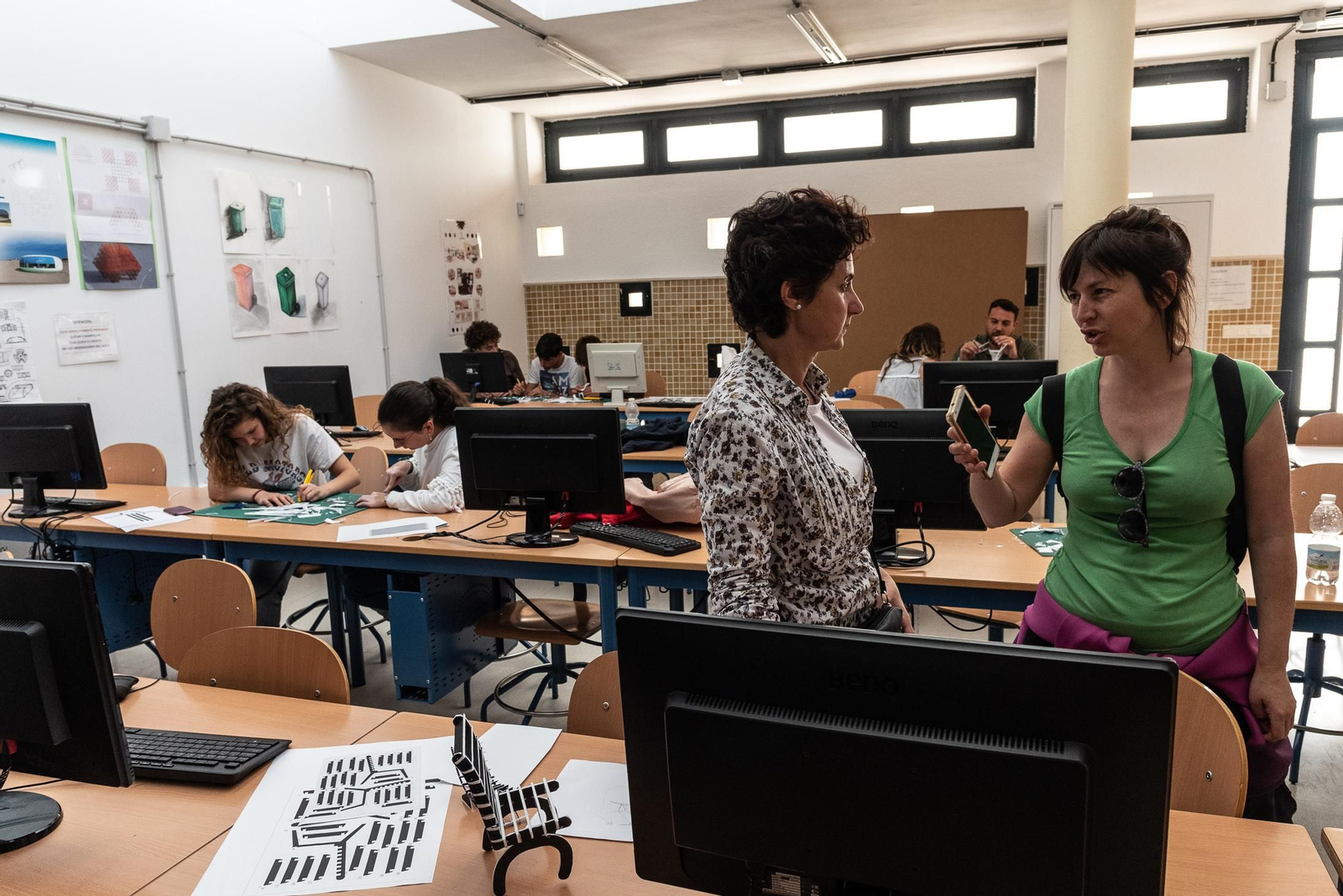 Profesores y estudiantes en el taller de diseño de sillas.