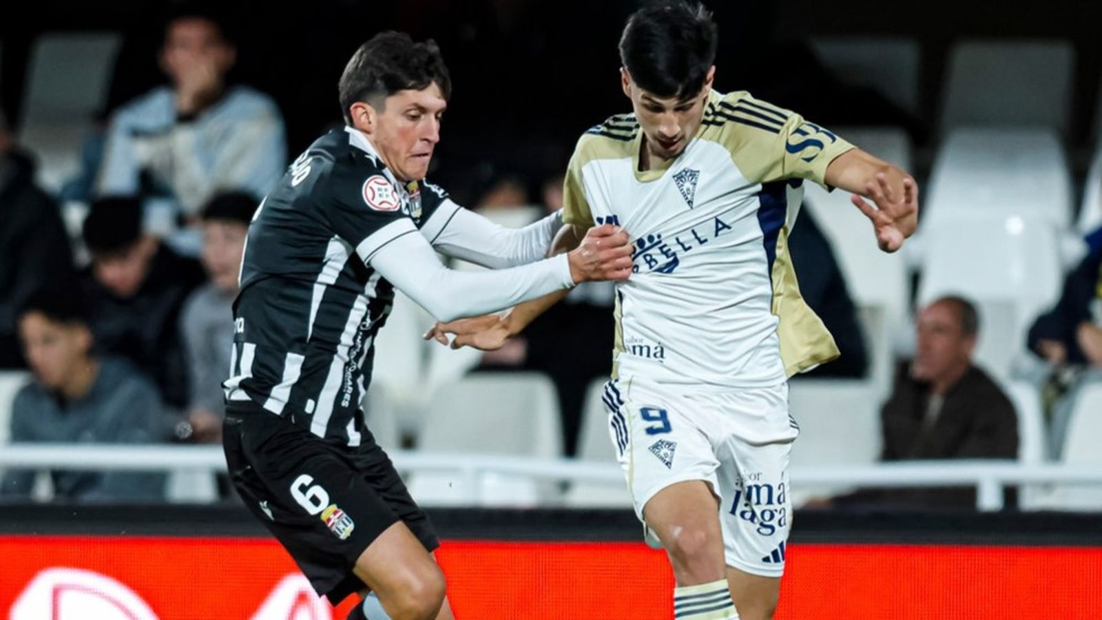 Víctor Sánchez es agarrado por un rival en su debut con el Marbella.