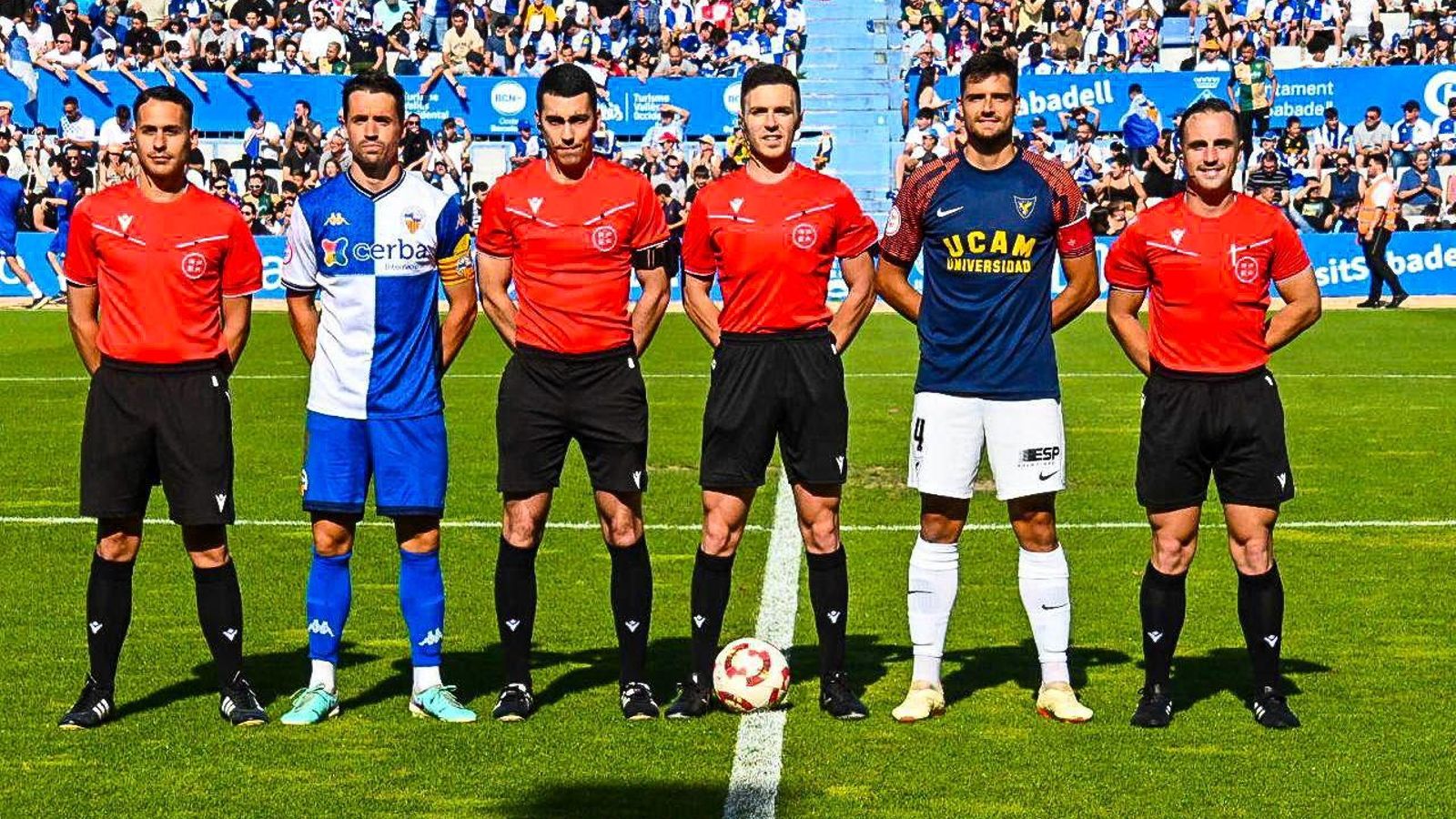 El almeriense Javi Ramírez, que portó el brazalete, posa con el cuarteto arbitral y el capitán del Sabadell antes del partido.