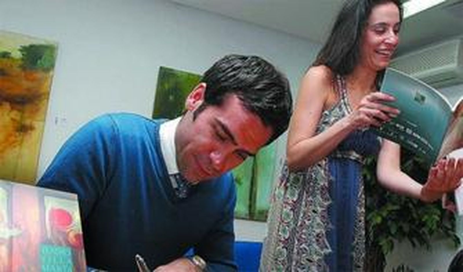 Ismael Jordi, acompañado de María Rey-Joly, firma en el libro de honor de 'Diario de Jerez'.