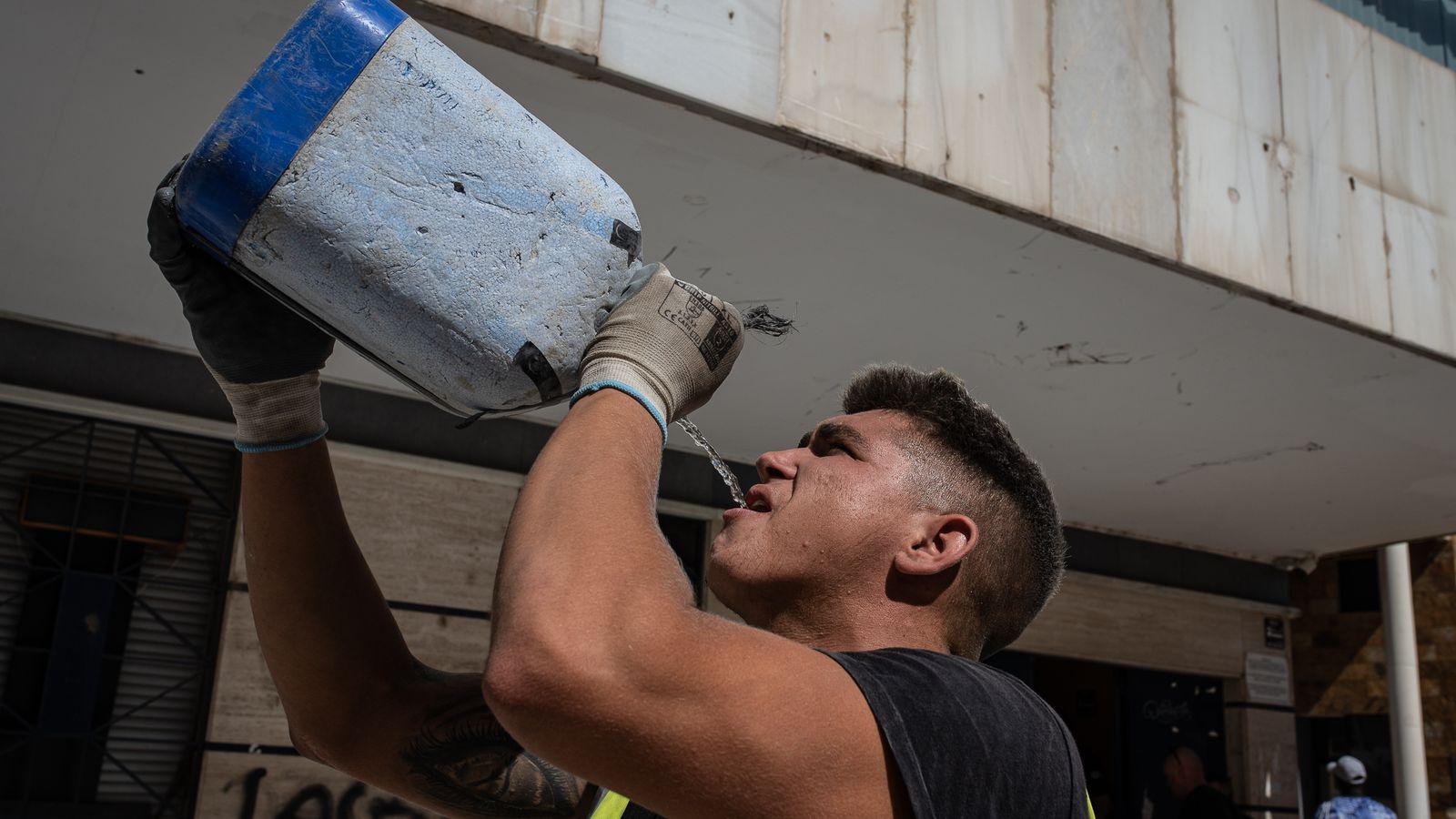 Los obreros beben litros y litros de agua para sobrellevar el calor.