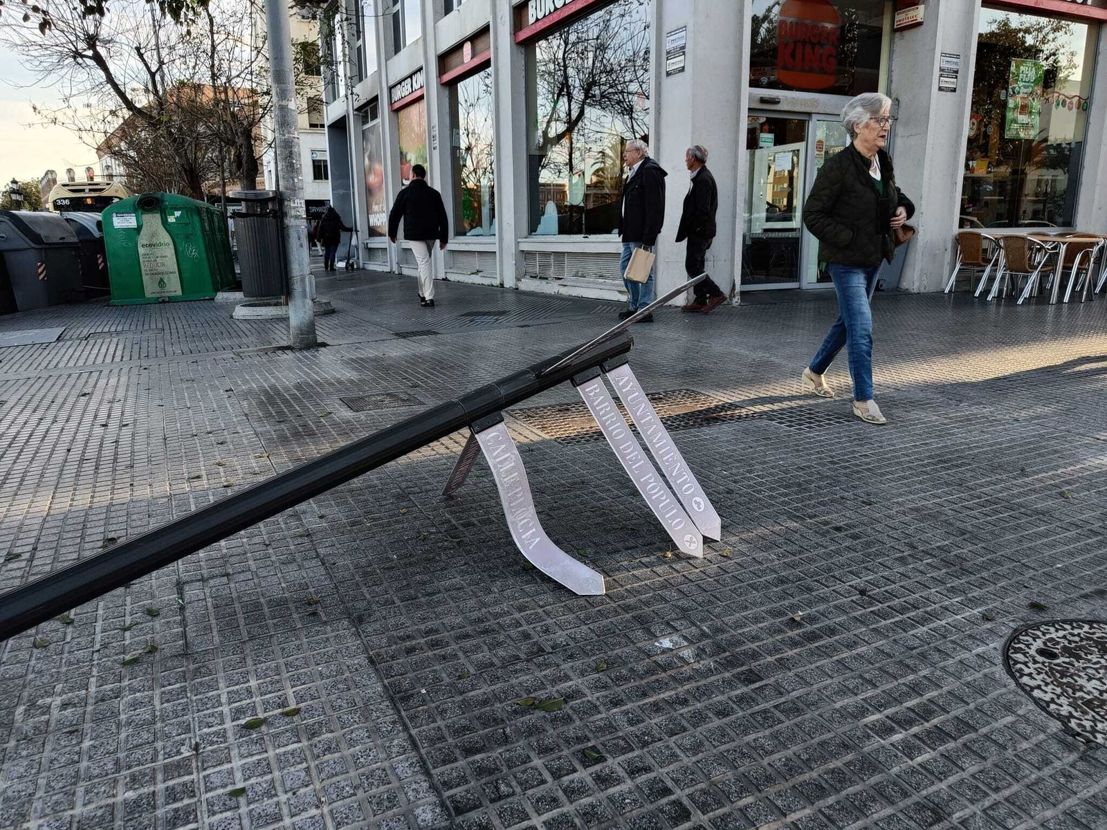 El poste de señalización municipal derribado, junto a los contenedores de la Avenida del Puerto, 2, esta misma tarde.