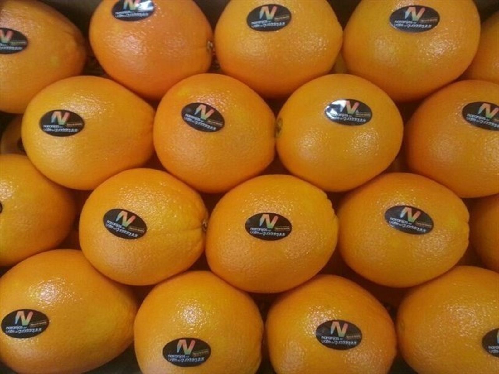 Naranjas apiladas en una caja.