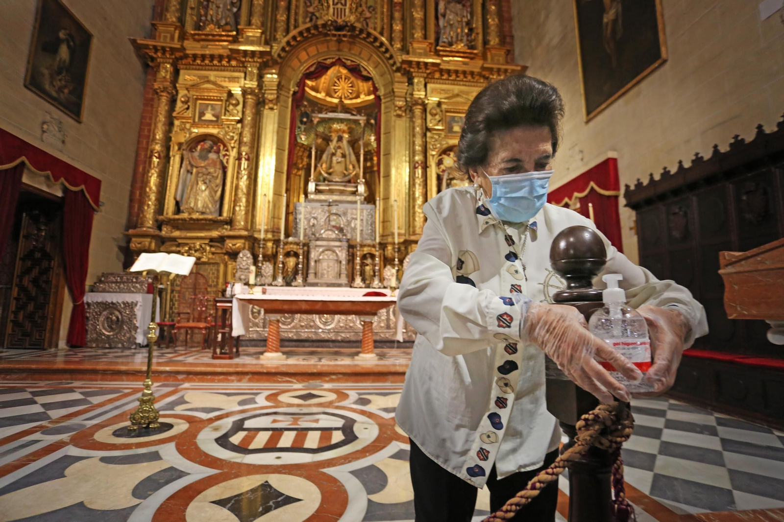 La conocida cofrade Ana María Salas, con la Patrona de fondo, preparando la basílica en la jornada de ayer.