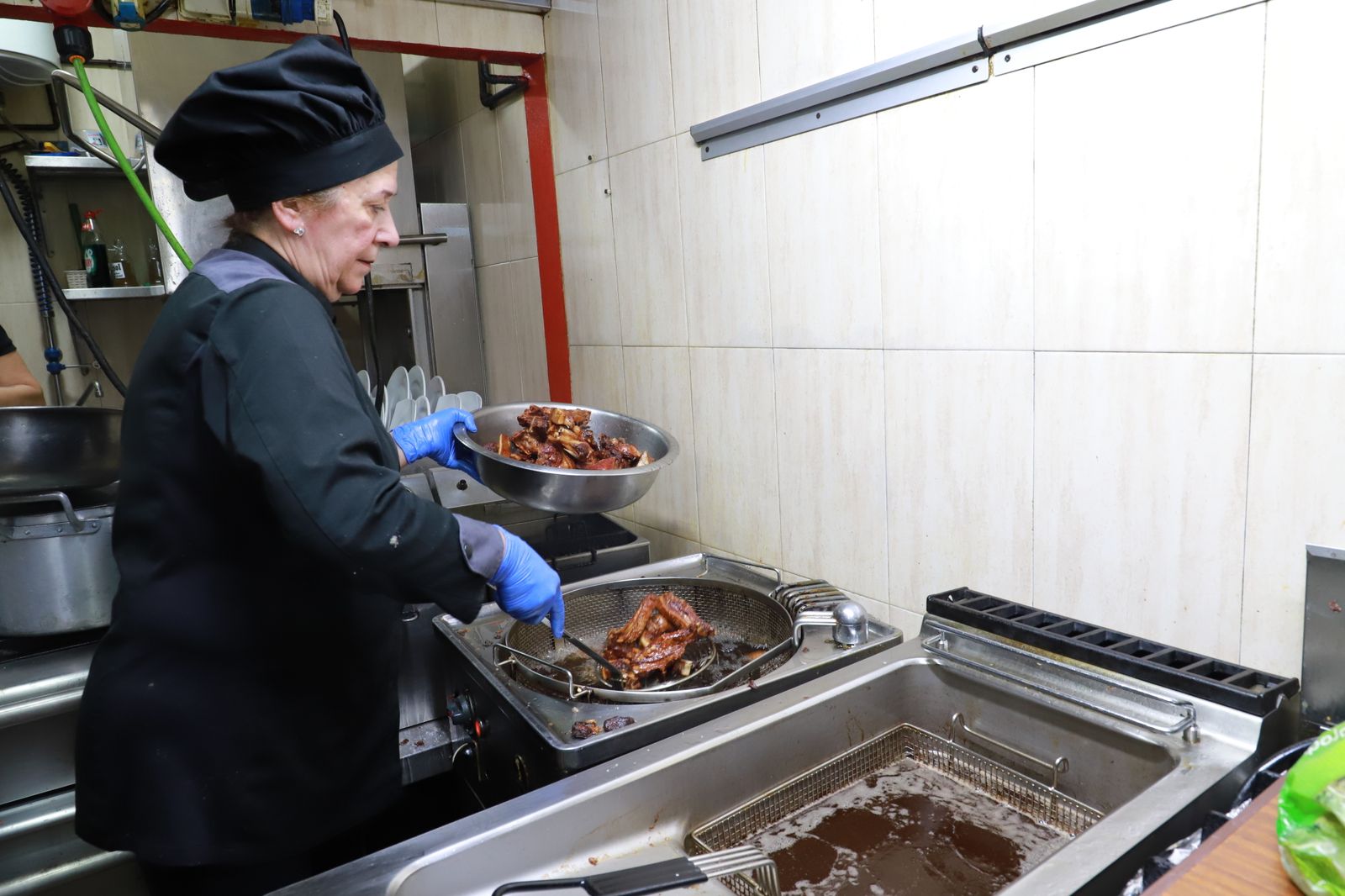Una de las cocineras de Casa Miguel prepara lechón ibérico.