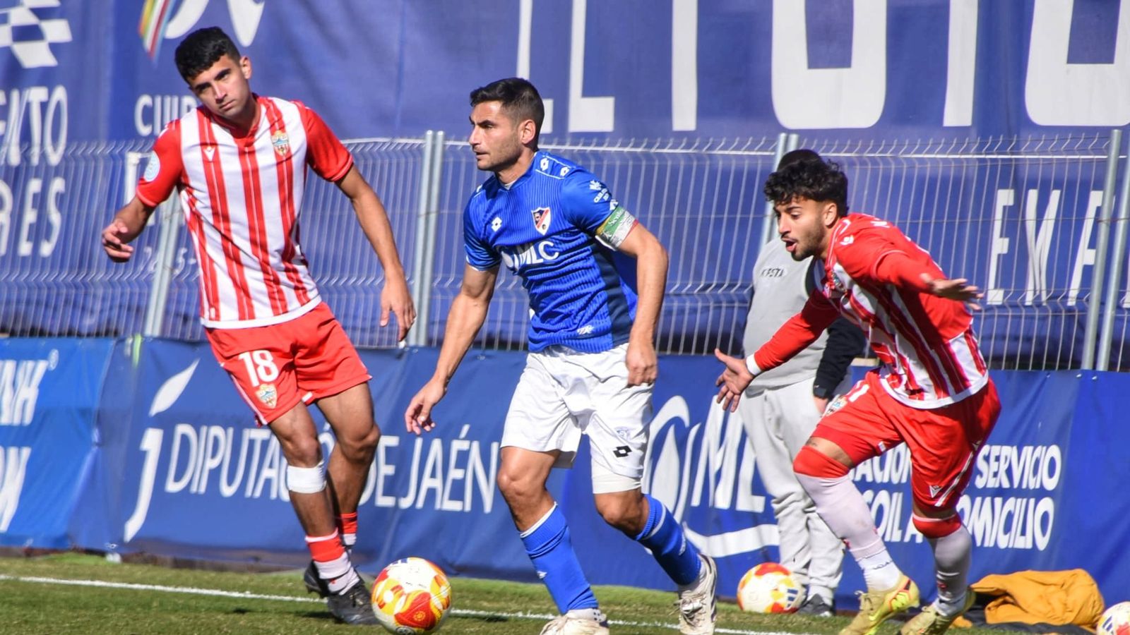 Fran Lara sale de la presión de dos rivales almerienses.