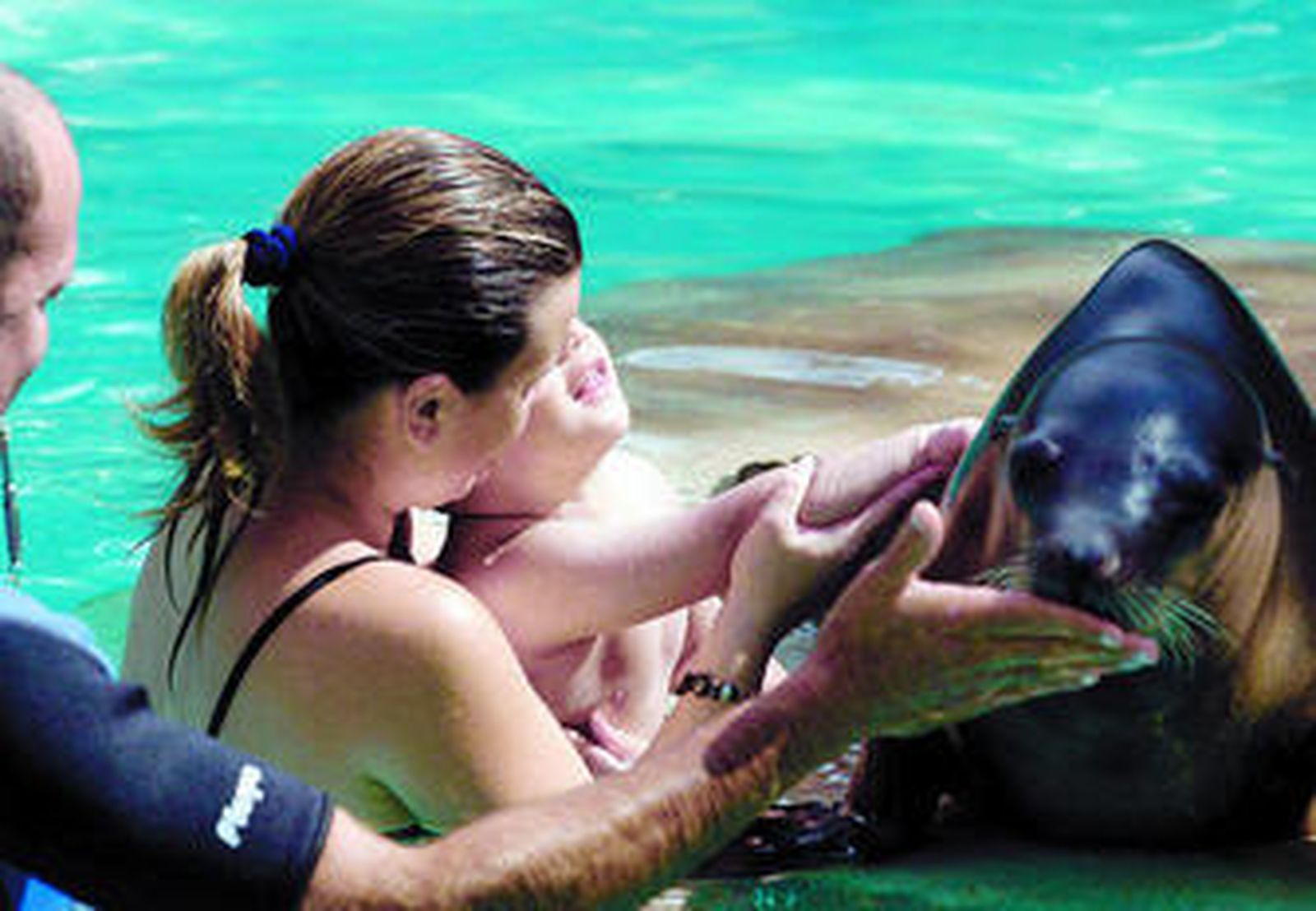 Un niño con síndrome de espectro autista nada junto a su madre en una actividad terapéutica con animales.