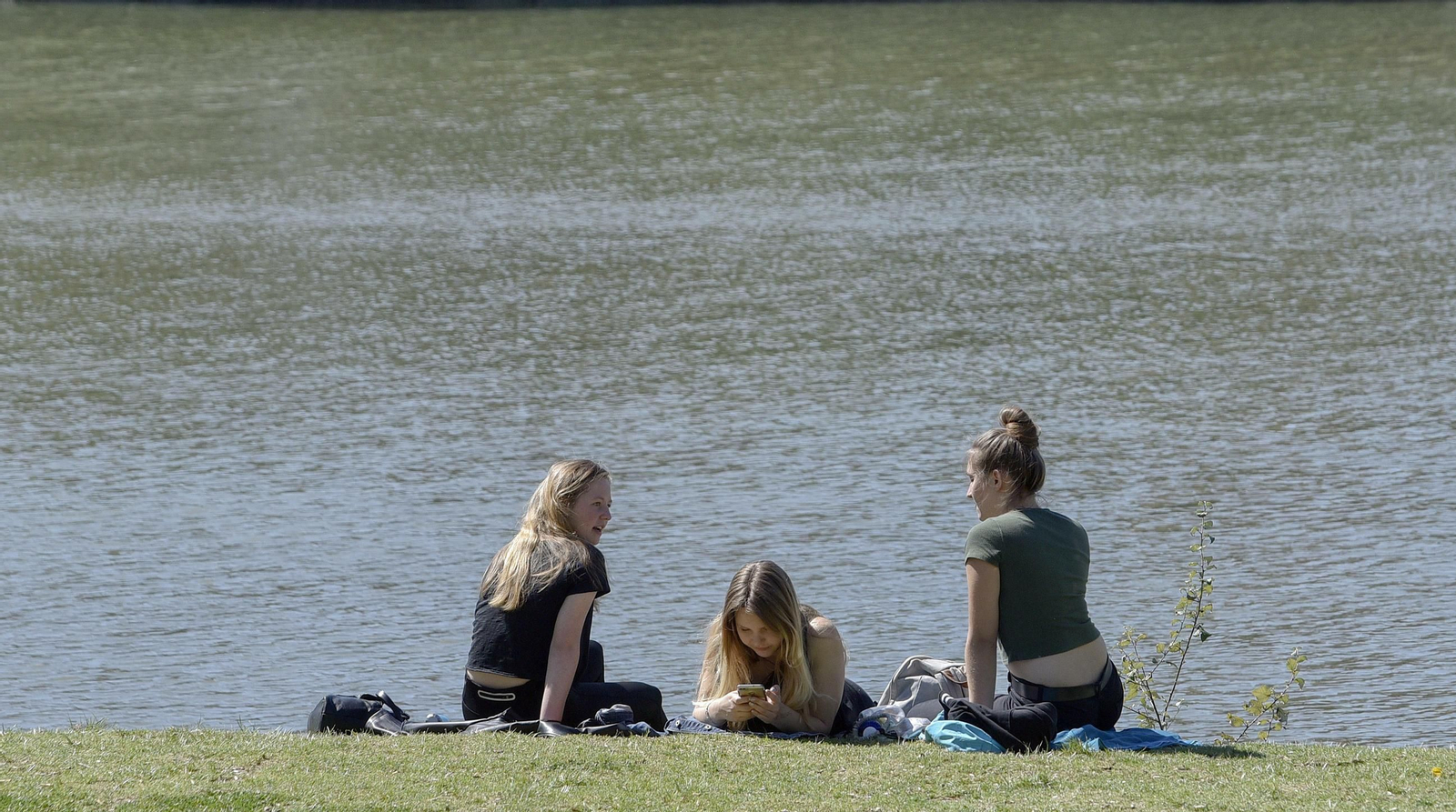 Tres jóvenes disfrutan al sol.