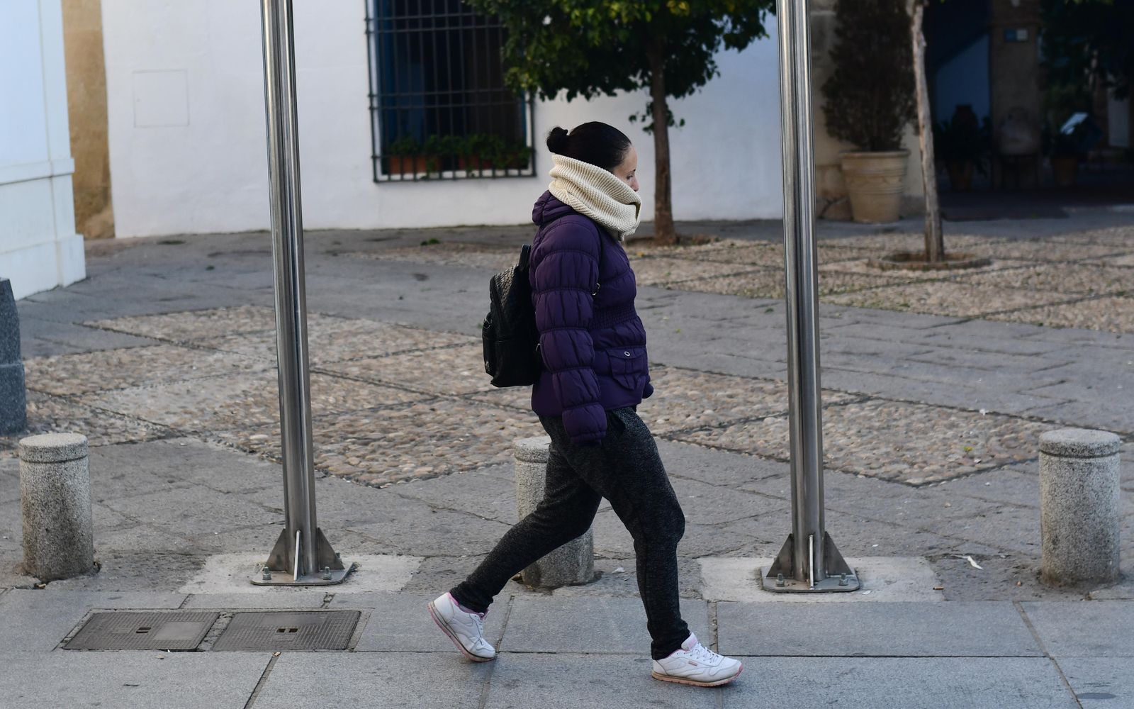 Una joven se protege del frío a primera hora de la mañana.