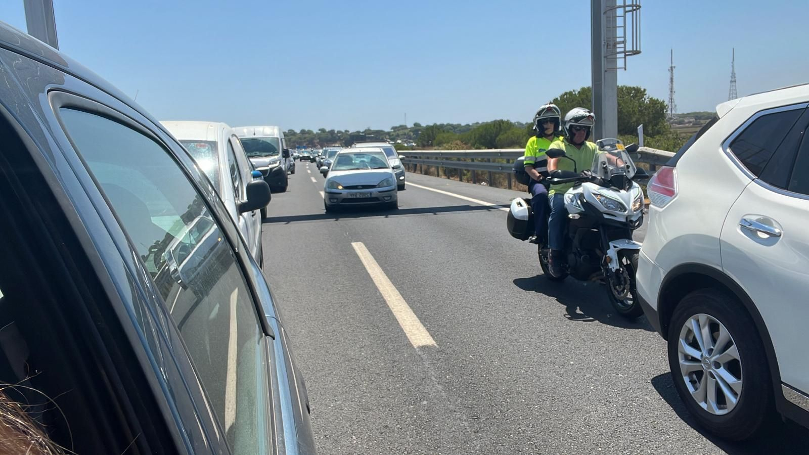 Largas colas de vehículos en la carretera que une Punta Umbría con Huelva, este lunes. Largas colas de vehículos en la carretera que une Punta Umbría con Huelva, este lunes.
