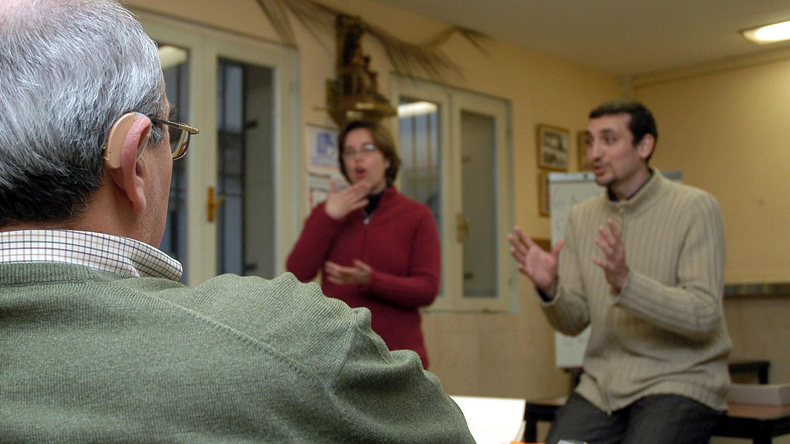 Una intérprete de signos asiste a una persona sorda durante una charla.