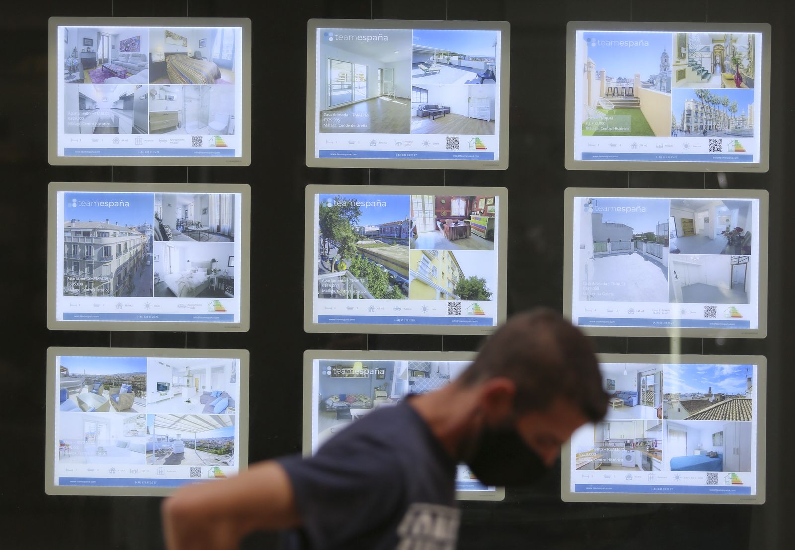 Un hombre pasa junto al escaparate de una inmobiliaria en Málaga.