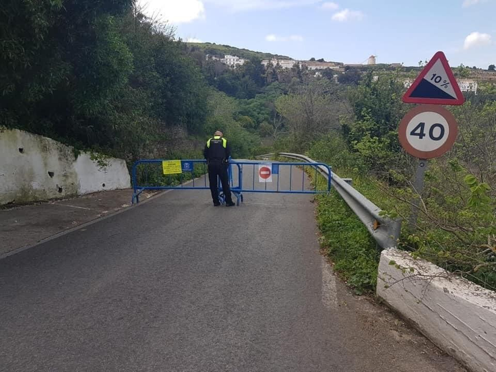 Un agente de la Policía Local junto a una de las vallas tiradas.