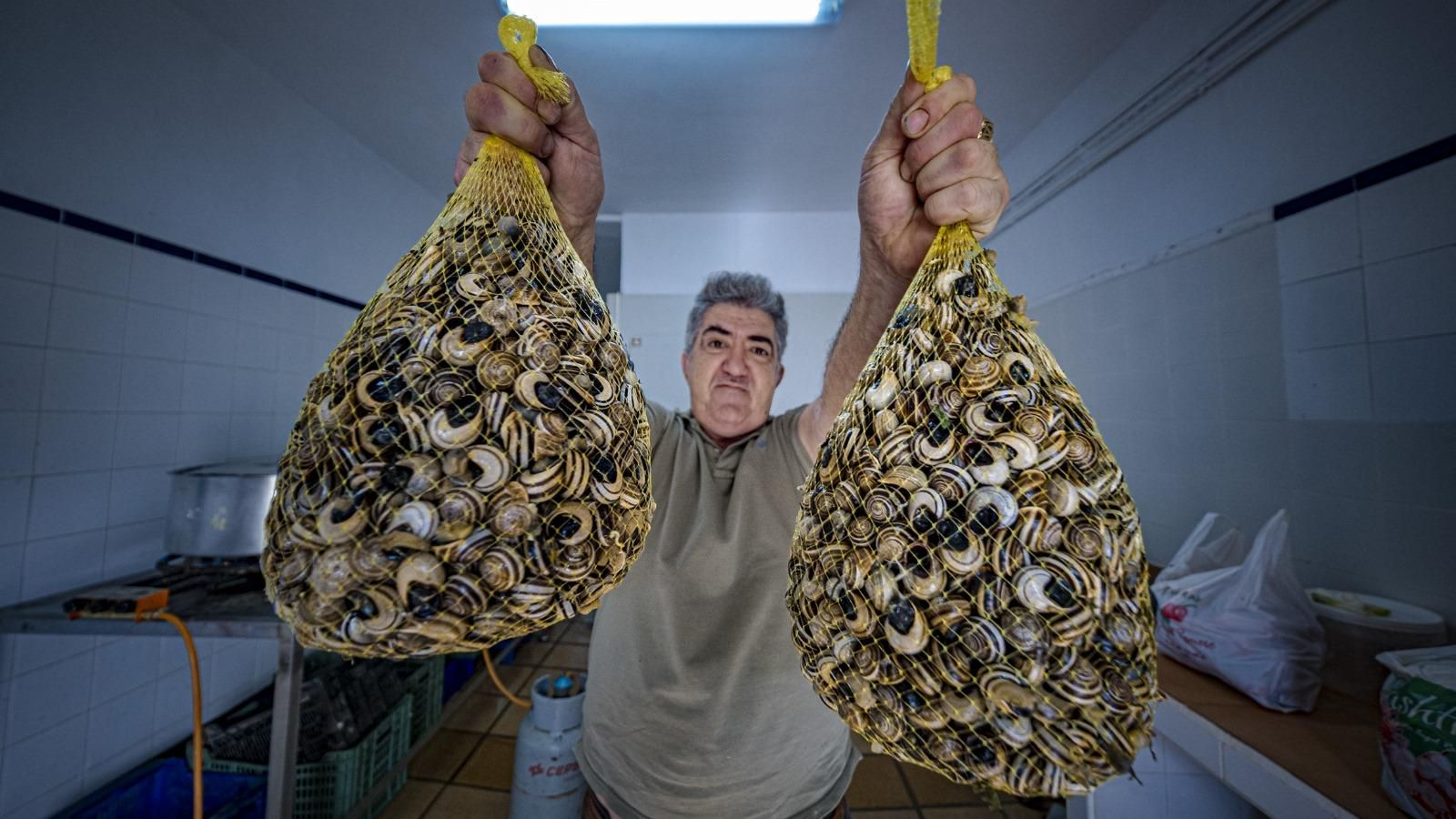 Domingo el Pavero sosteniendo dos grandes sacos de caracoles. Domingo el Pavero sosteniendo dos grandes sacos de caracoles.