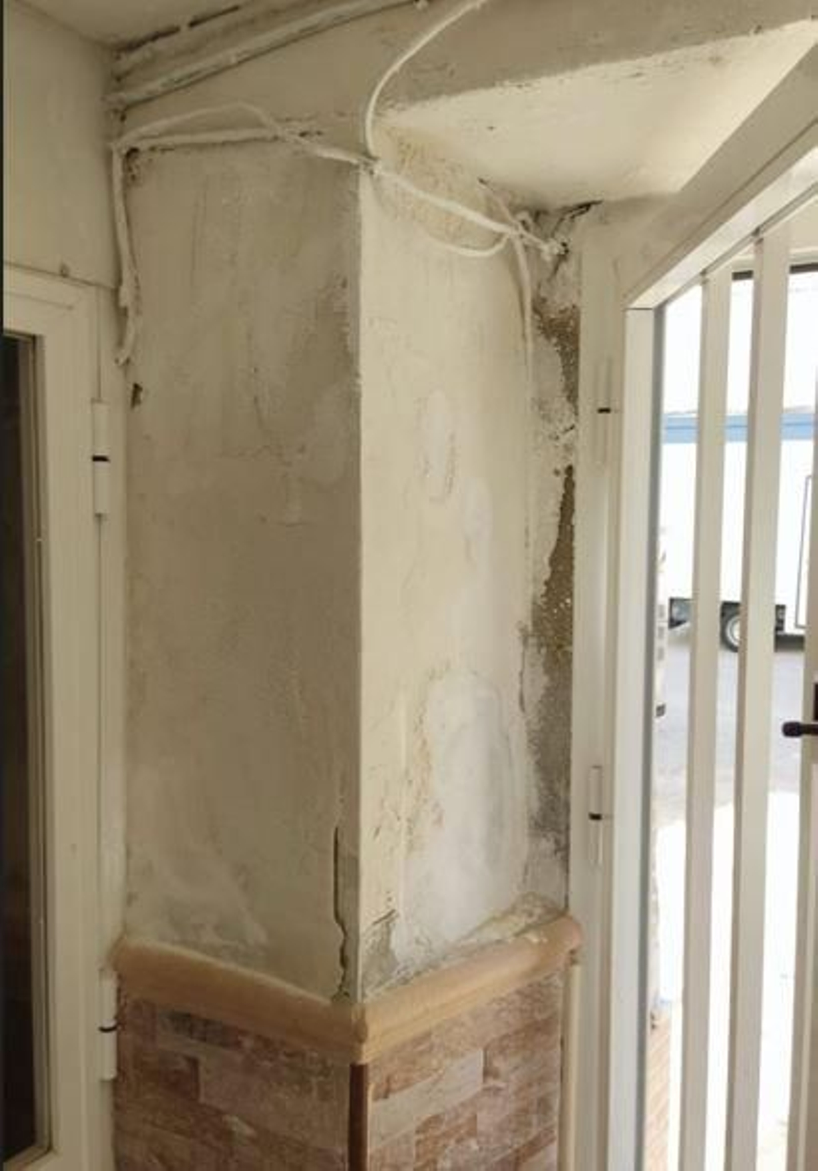 Humedades en uno de los portales de un bloque rehabilitado.