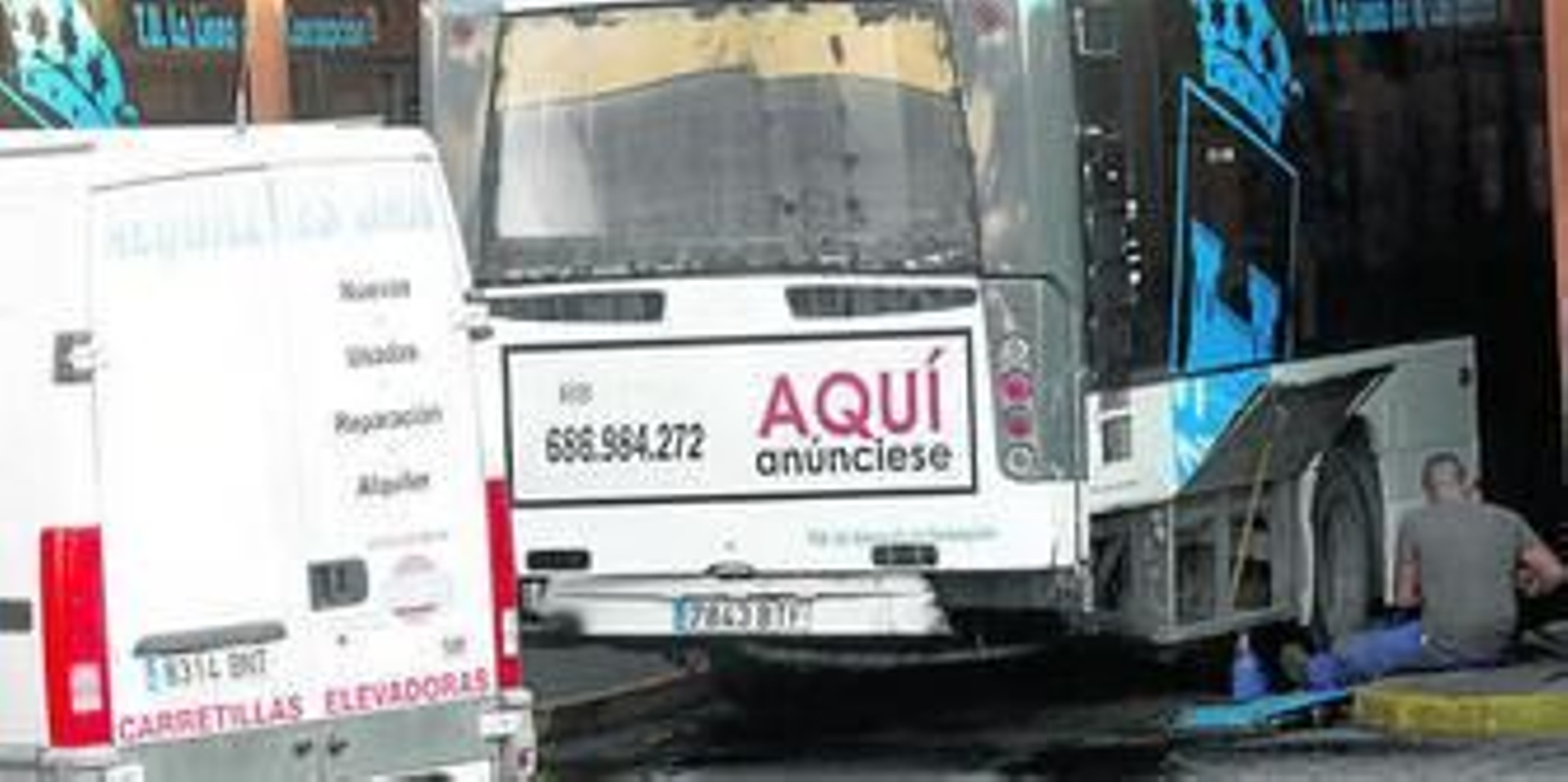 Un mecánico repara uno de los autobuses estacionado junto a otro también averiado.
