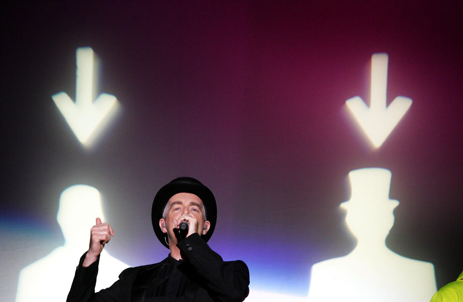 El vocalista de Pet Shop Boys, Neil Tennant, señala la silueta de su compañero, en un momento de su concierto.