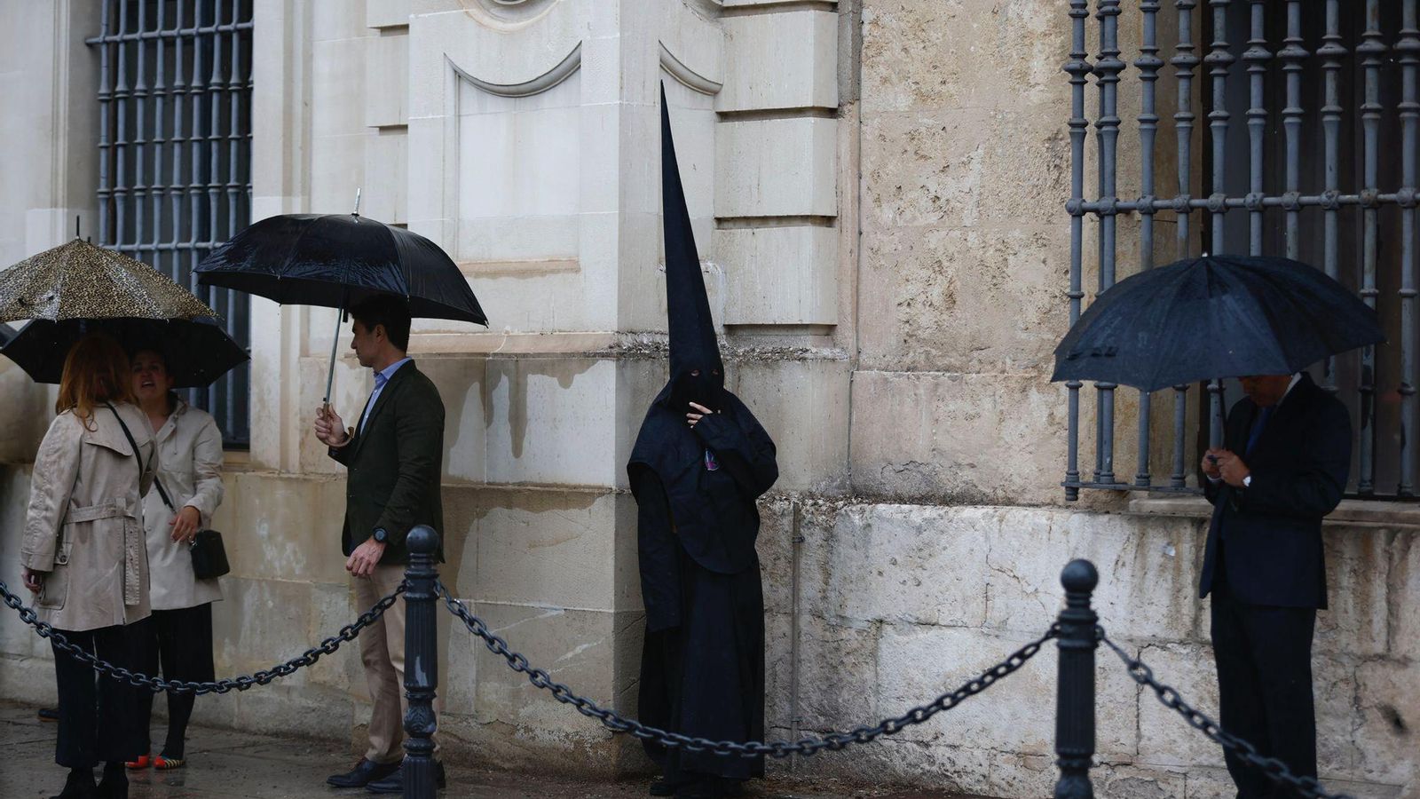 Un nazareno de los Estudiantes se guarece en una esquina