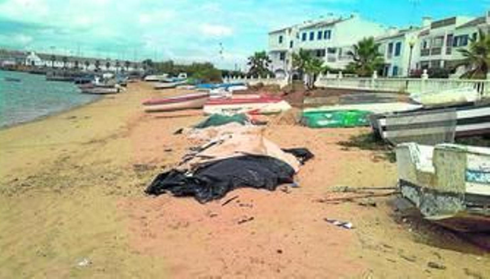 La playa de El Cantil, en Isla Cristina, al abrigo de la ría del Carreras. A la derecha, los chalés afectados.
