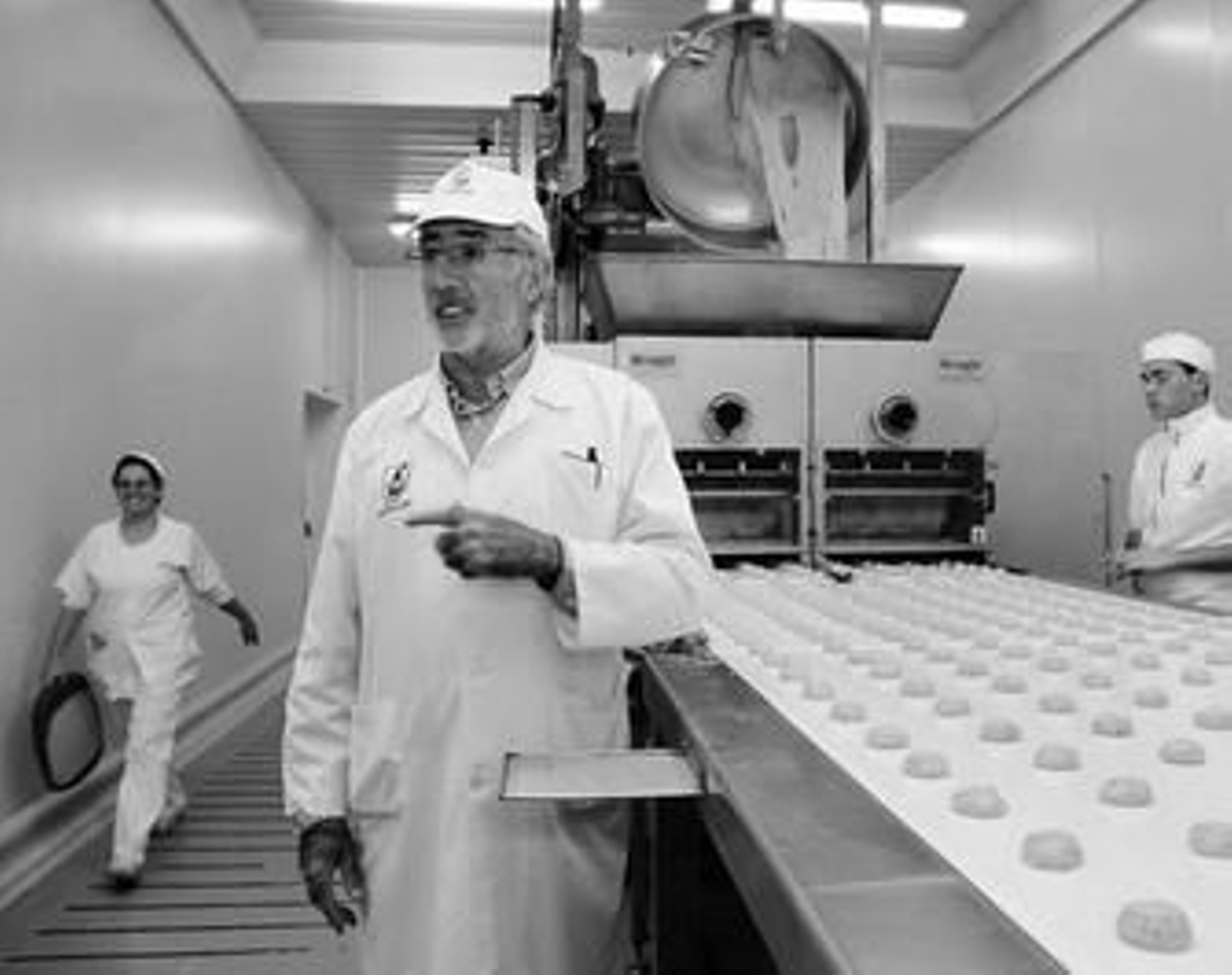 1. Juan Moreno junto a la divisora, la máquina que hace las porciones de cada torta y que las sitúa en una cinta transportadora. 2. Un grupo de 16 operarias dan forma a mano a las tortas antes de ser horneadas en la misma cinta transportadora. 3. Tras enfriarse, las tortas son empaquetadas en papel una a una, a razón de 22 tortas por minuto y operaria.