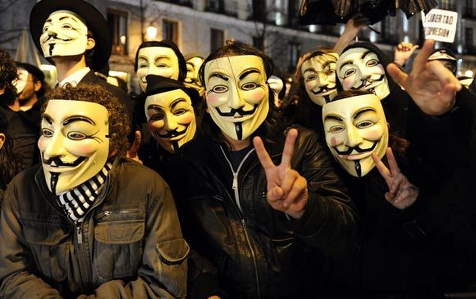 Activistas de Anonymous protestan a la entrada del Teatro Real. / EFE · Reuters · AFP