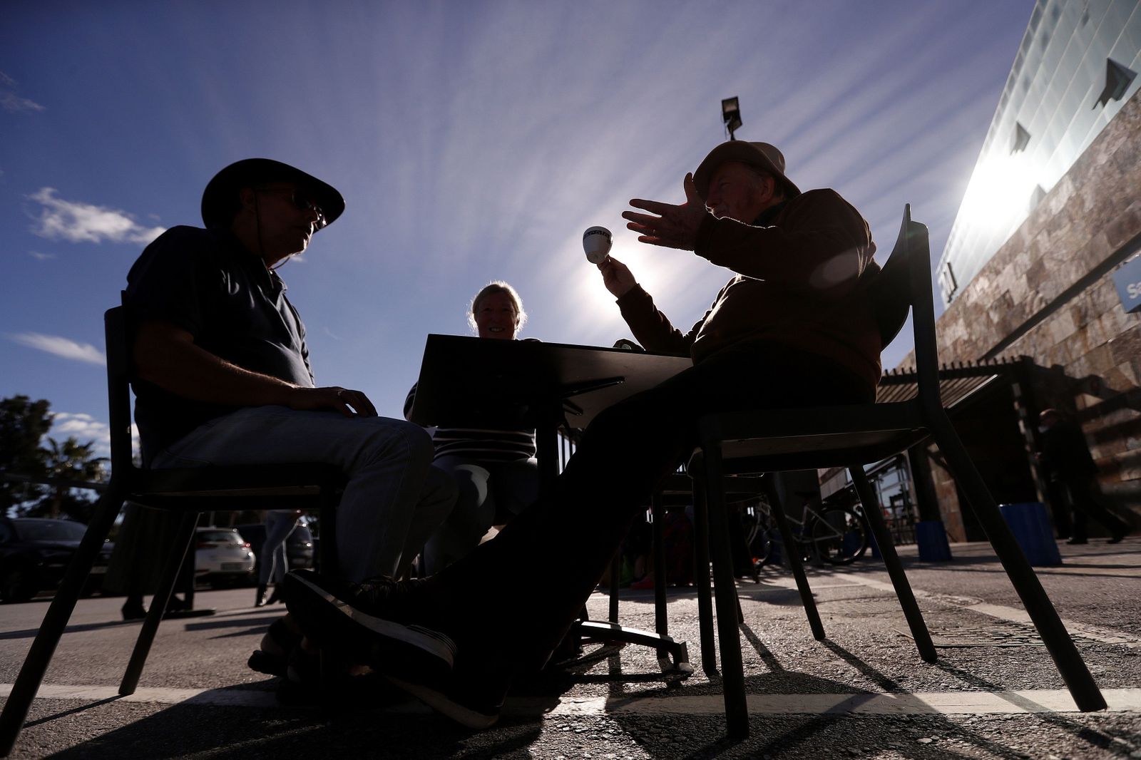 Dos personas discuten en la terraza de un bar.