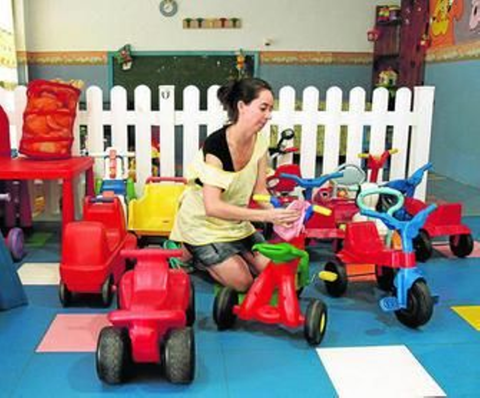 La trabajadora de una guardería prepara los juguetes que utilizarán los niños.