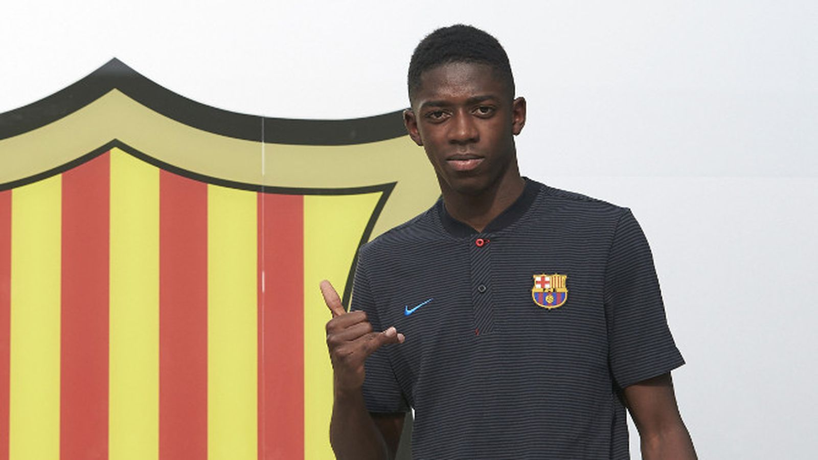 Dembélé posa junto al escudo del Barça.