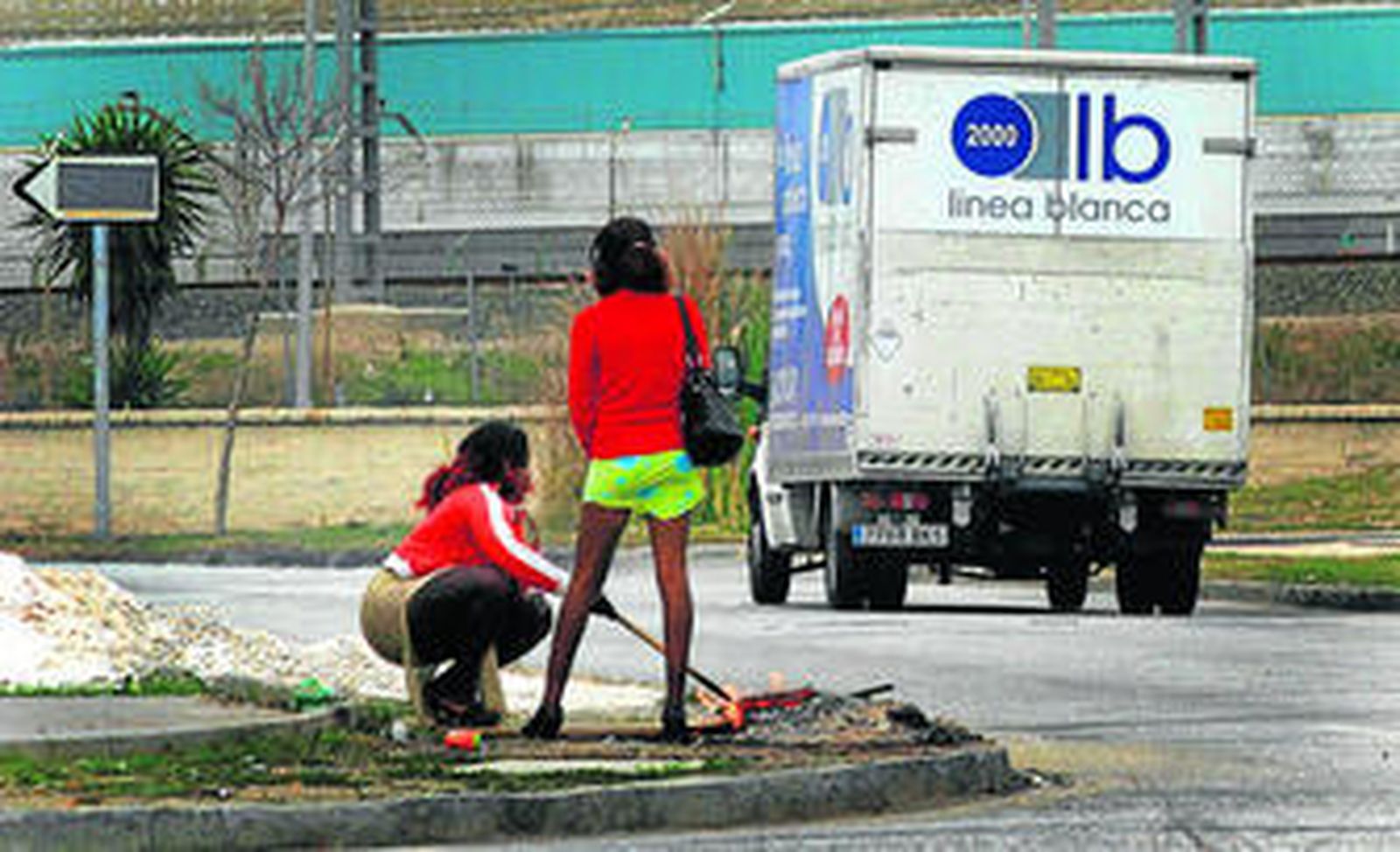 Dos prostitutas se calientan en torno a un fuego en el polígono Guadalhorce de la capital.