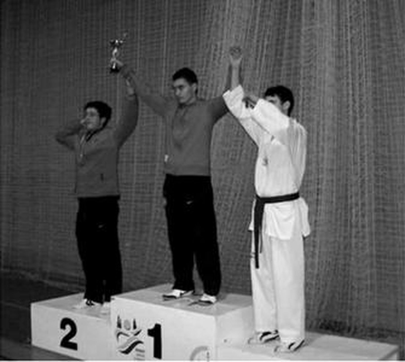 David Cárdenas (centro), alza las manos con su trofeo de campeón.