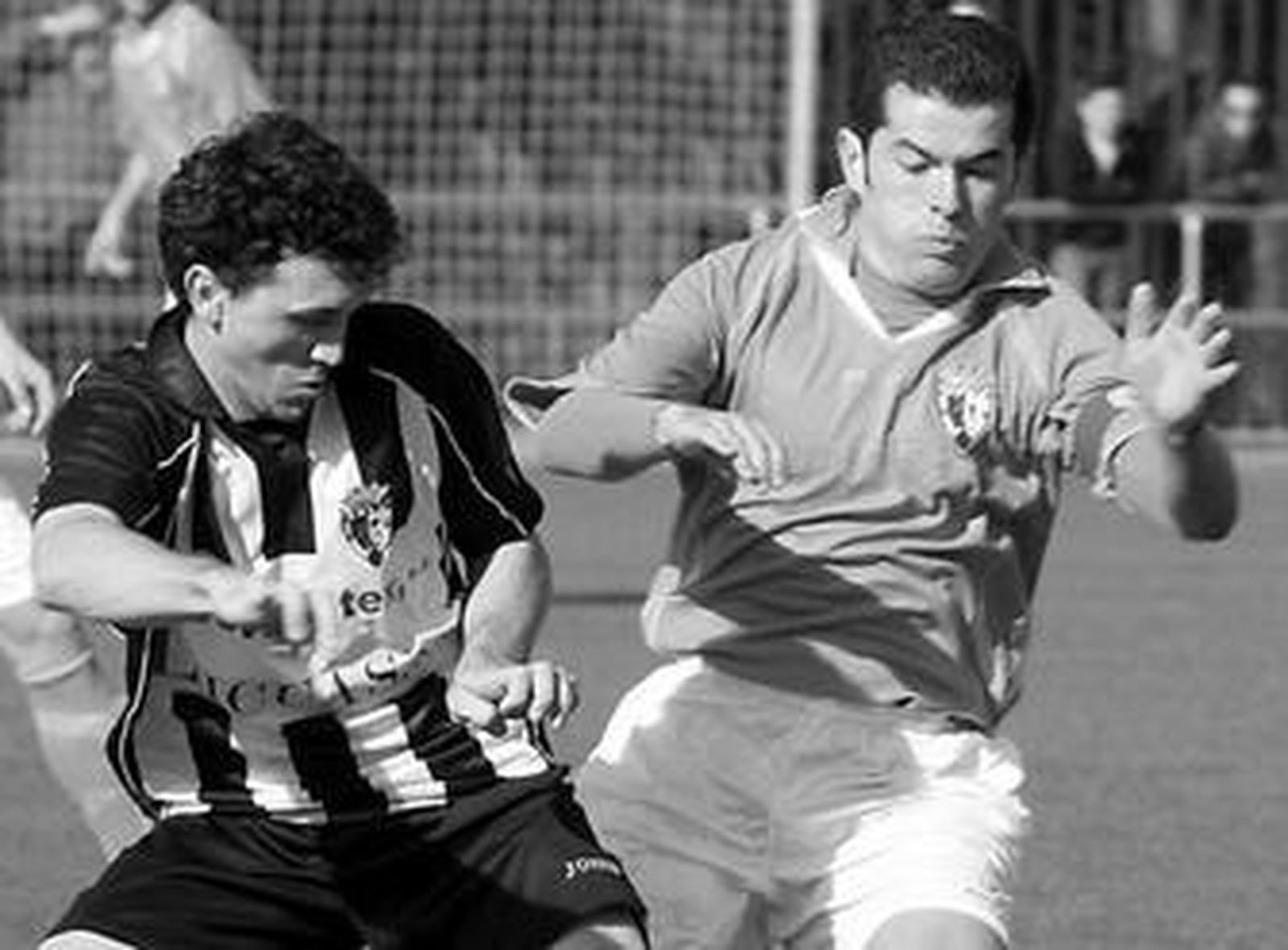 El industrialista Paquito (d) encima de un jugador sevillano.