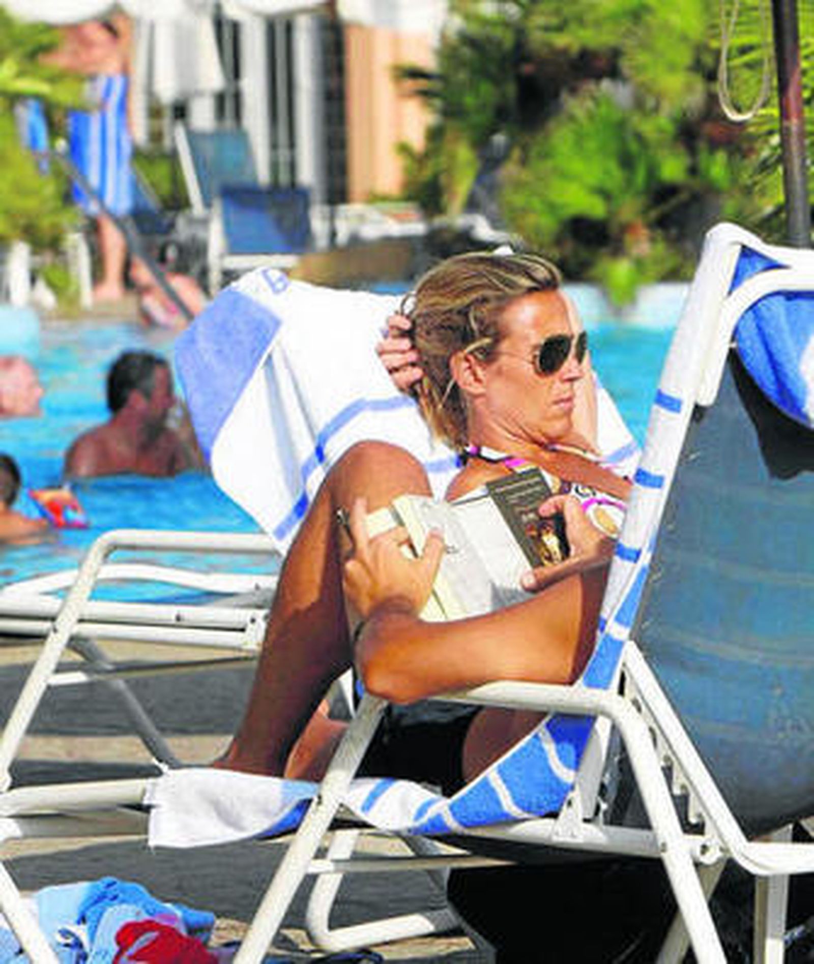 Varios turistas disfrutan de una piscina.