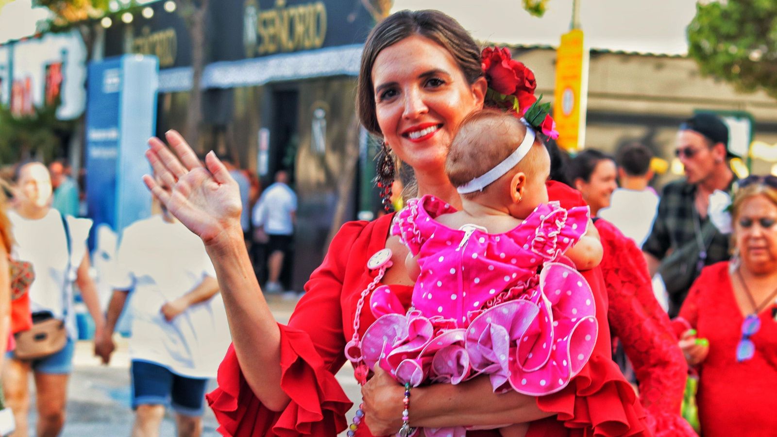 Una flamenca despidiéndose de la Feria con su hija en brazos